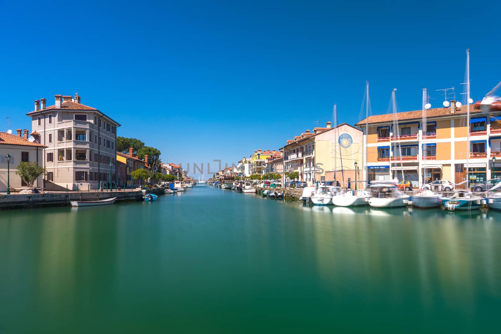 Grado - March 2016, Italy: Canal with sail boats lying on water in small Italian town of Grado