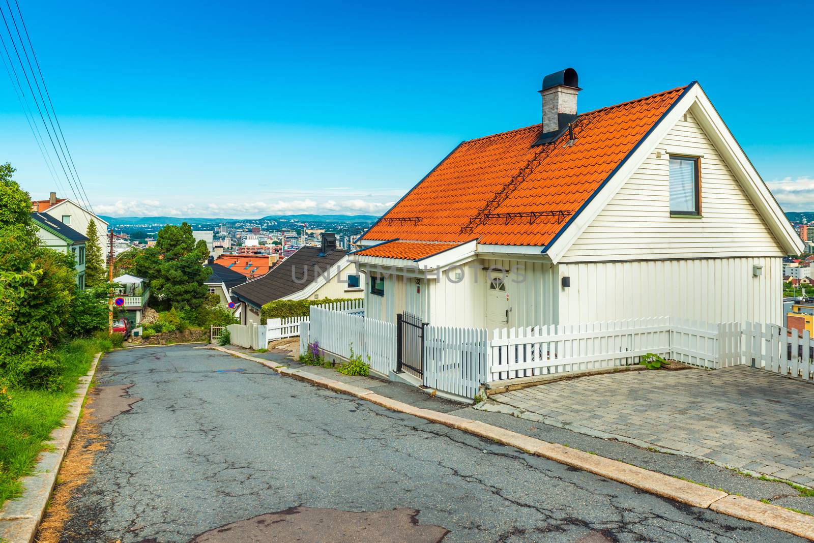 Oslo - June 2019, Norway: View of an empty street on one of the hills around the city. Wooden white house with orange roof