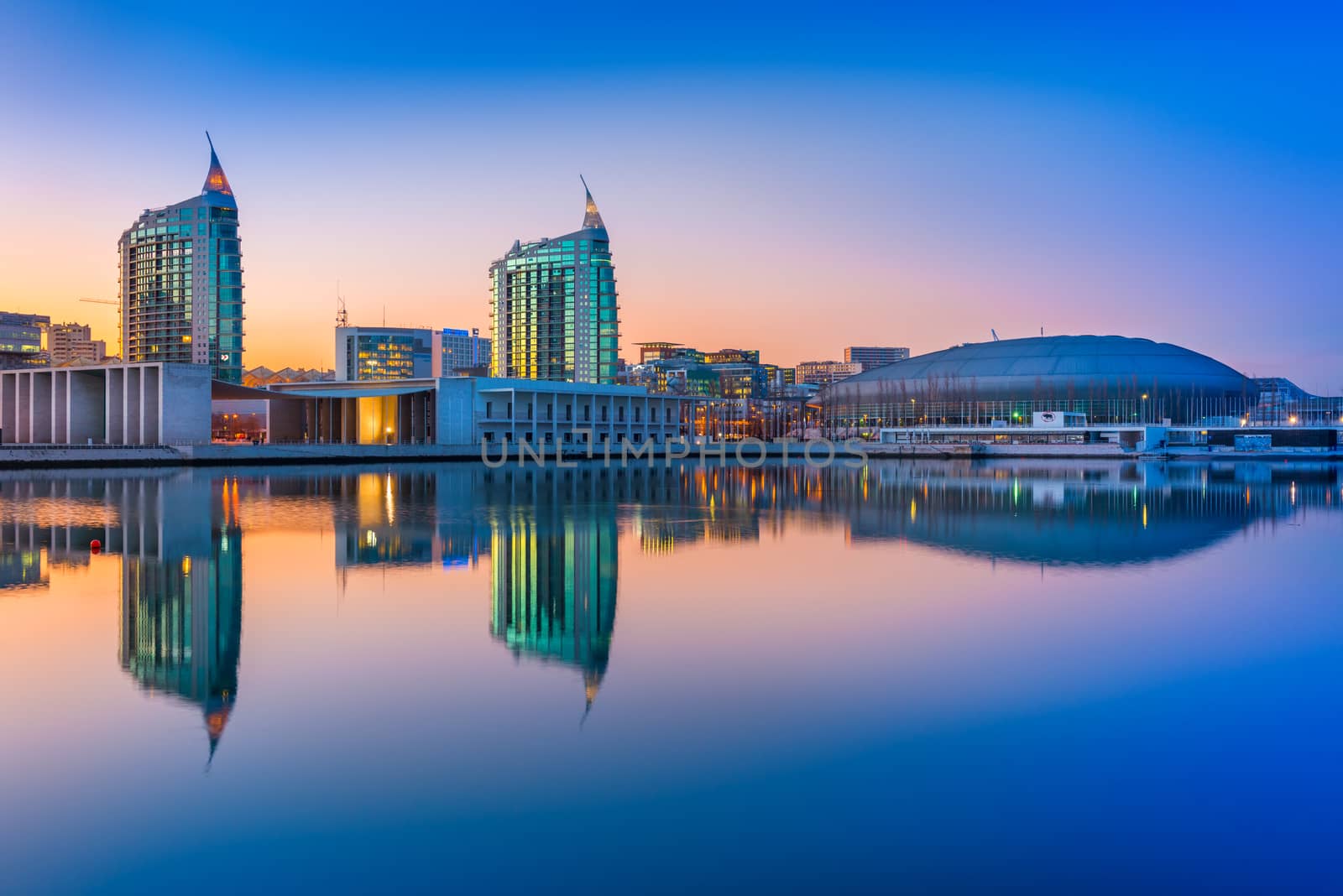 Lisbon - February 2019, Portugal: Sunset at The Nations Park (Parque das Nações) in Lisbon. Modern buildings and Altice Arena mirrored in the water