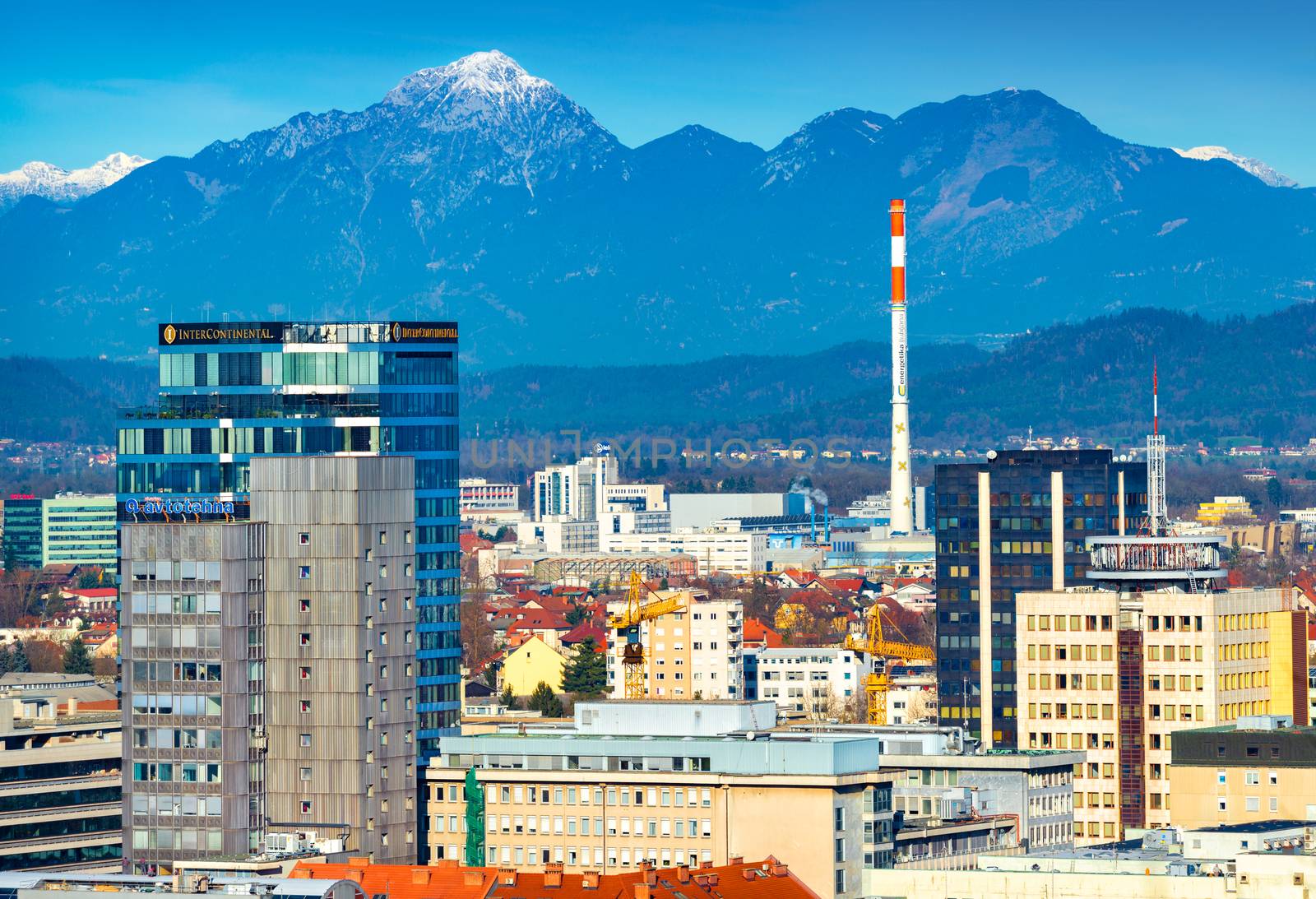Ljubljana - December 2019, Slovenia: View of the modern buildings in downtown Ljubljana with beautiful snowy Alps in the background