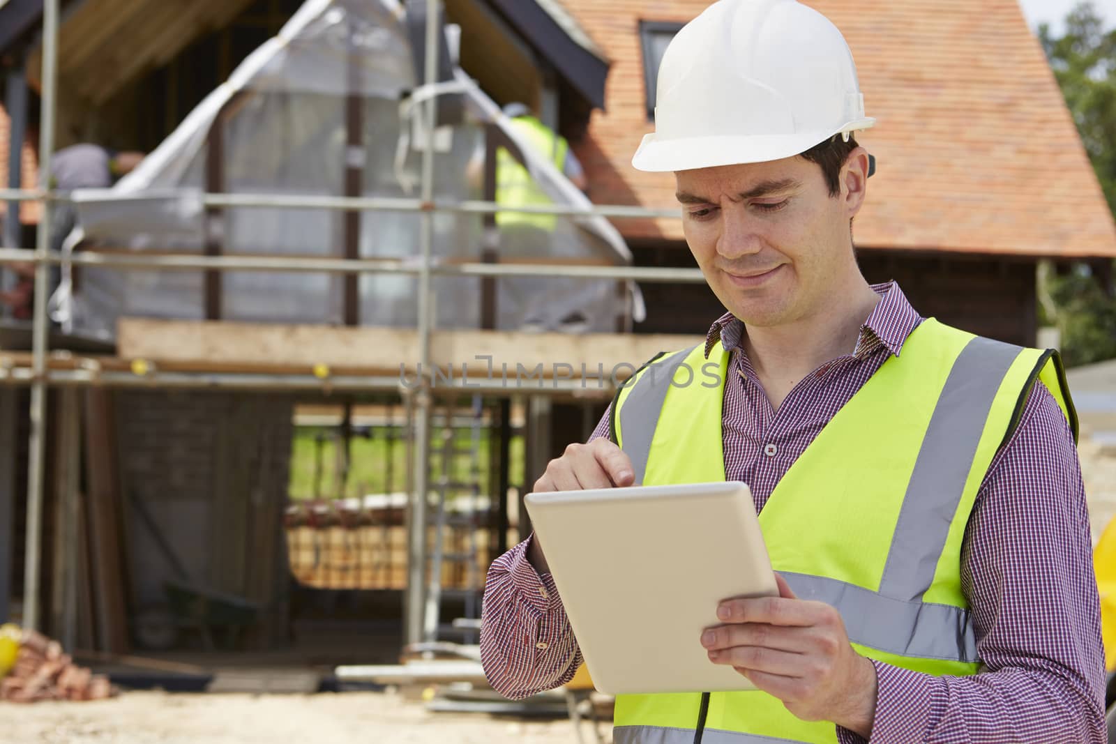 Architect On Building Site Using Digital Tablet by HWS