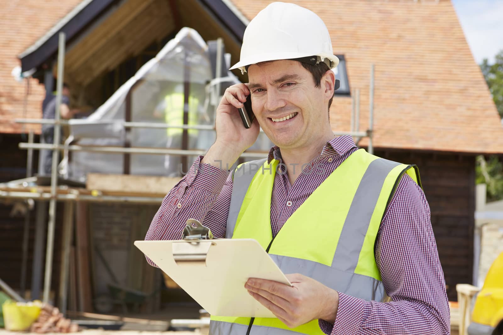 Architect On Building Site Using Mobile Phone by HWS
