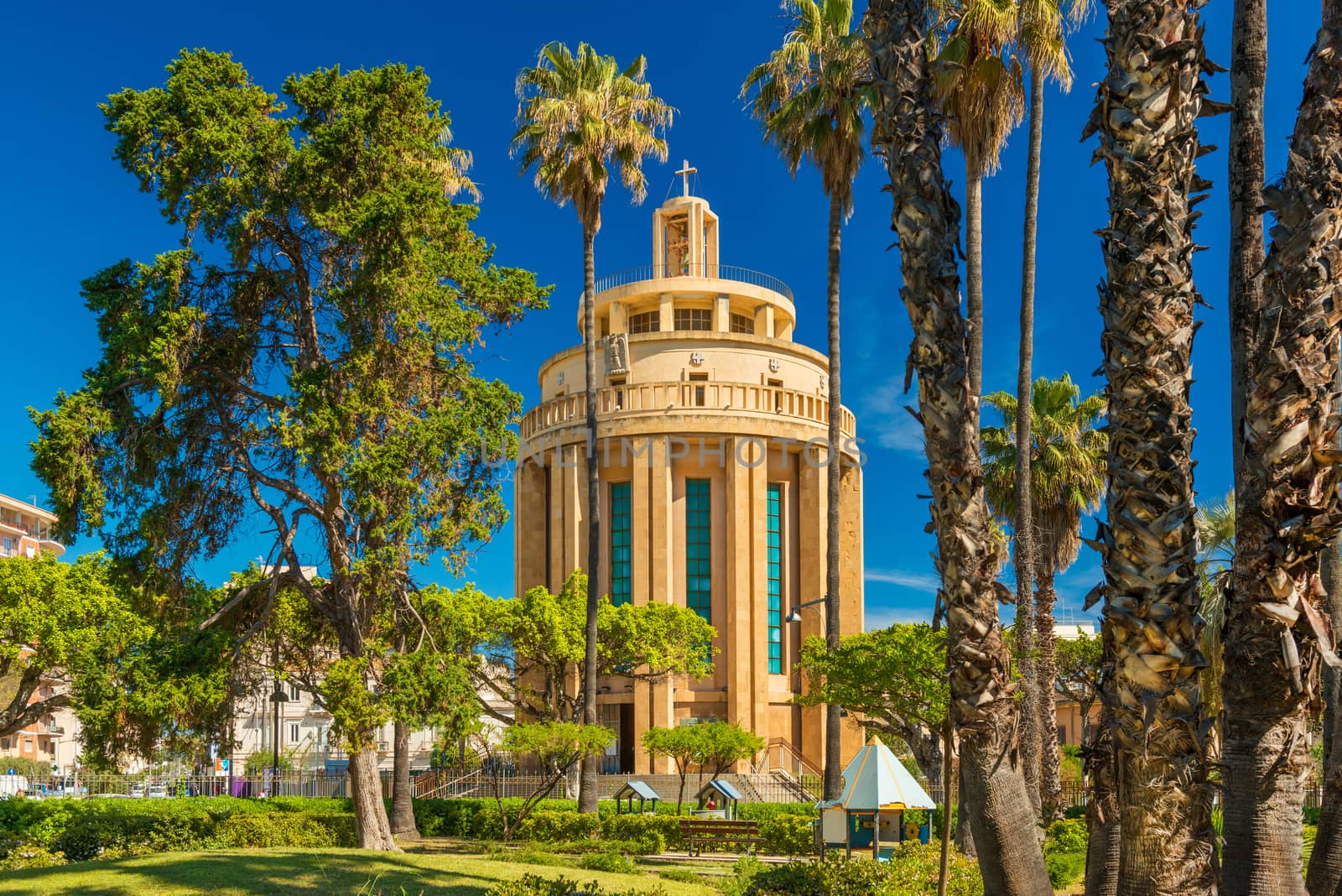 Syracuse - April 2019, Sicily, Italy: The Pantheon building (Chiesa di San Tommaso al Pantheon) in Syracuse (Siracusa), view through palm trees in the city park