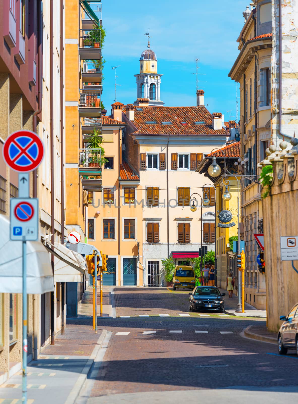 Udine - August 2016, Friuli Venezia Giulia region, Italy: Picturesque view of the old medieval street in historic center of Udine, old colored historical houses and  cars parked near them