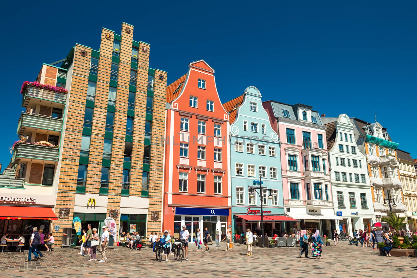 Rostock - July 2018, Germany: Colored historical houses on the central square of the city. People are walking along the street