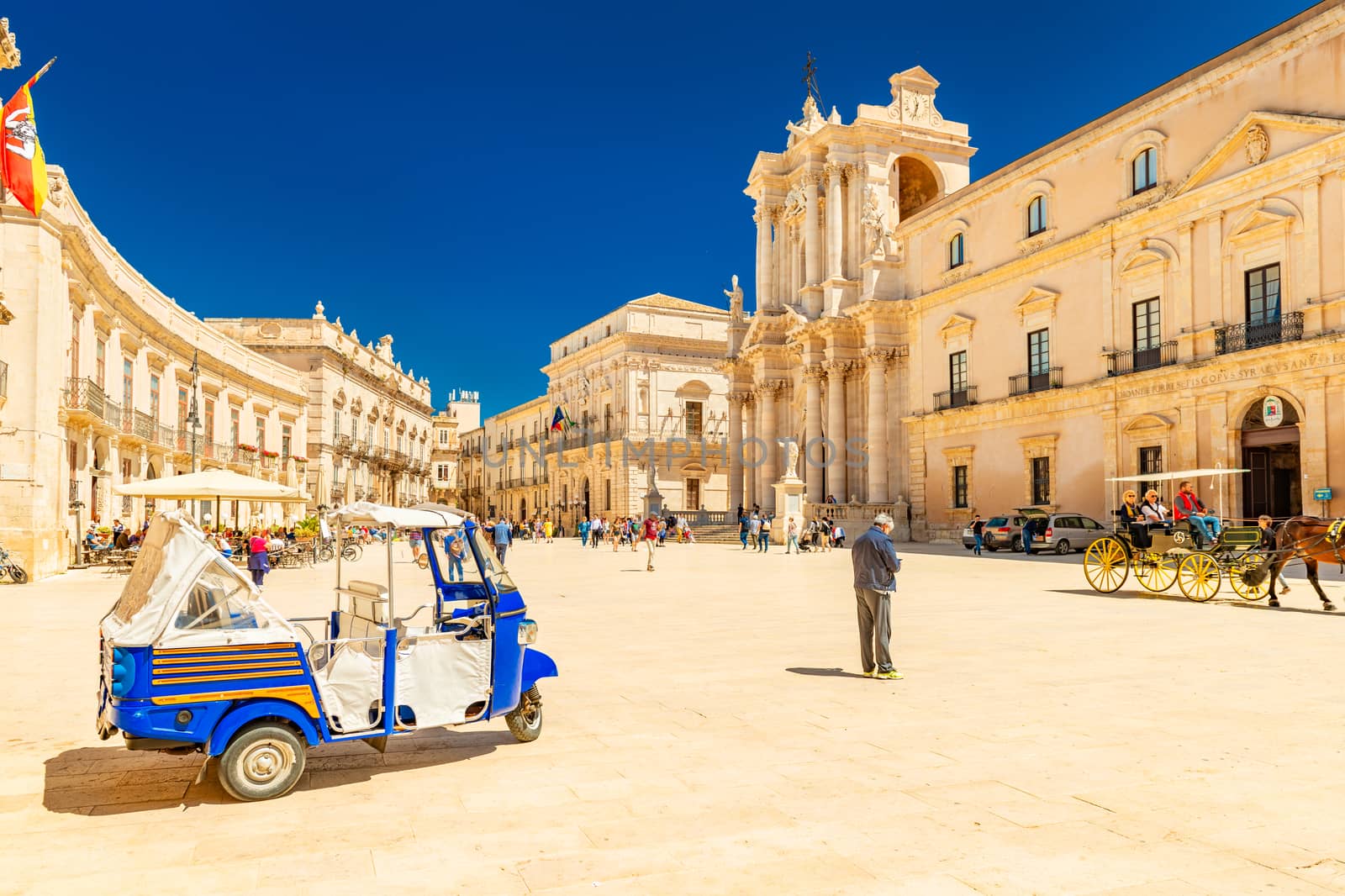 Ortygia - April 2019, Syracuse, Italy: View of The Cathedral of Syracuse and the central square (Piazza Duomo) with walking people