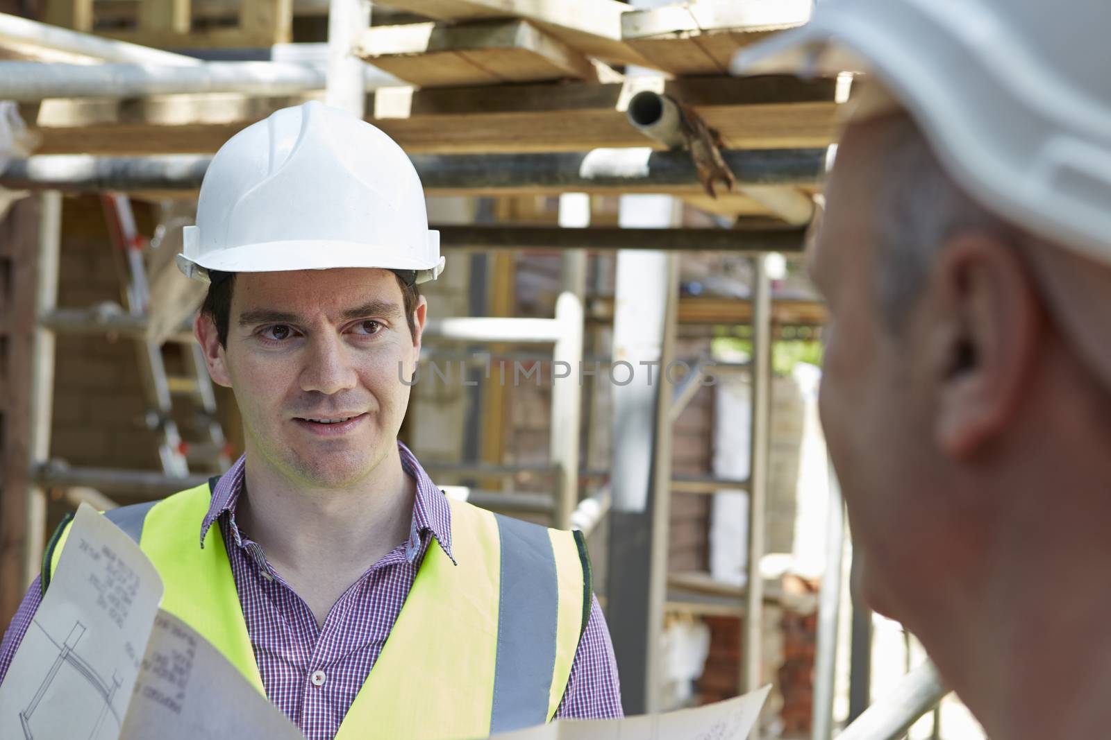 Architect Discussing Plans With Builder by HWS