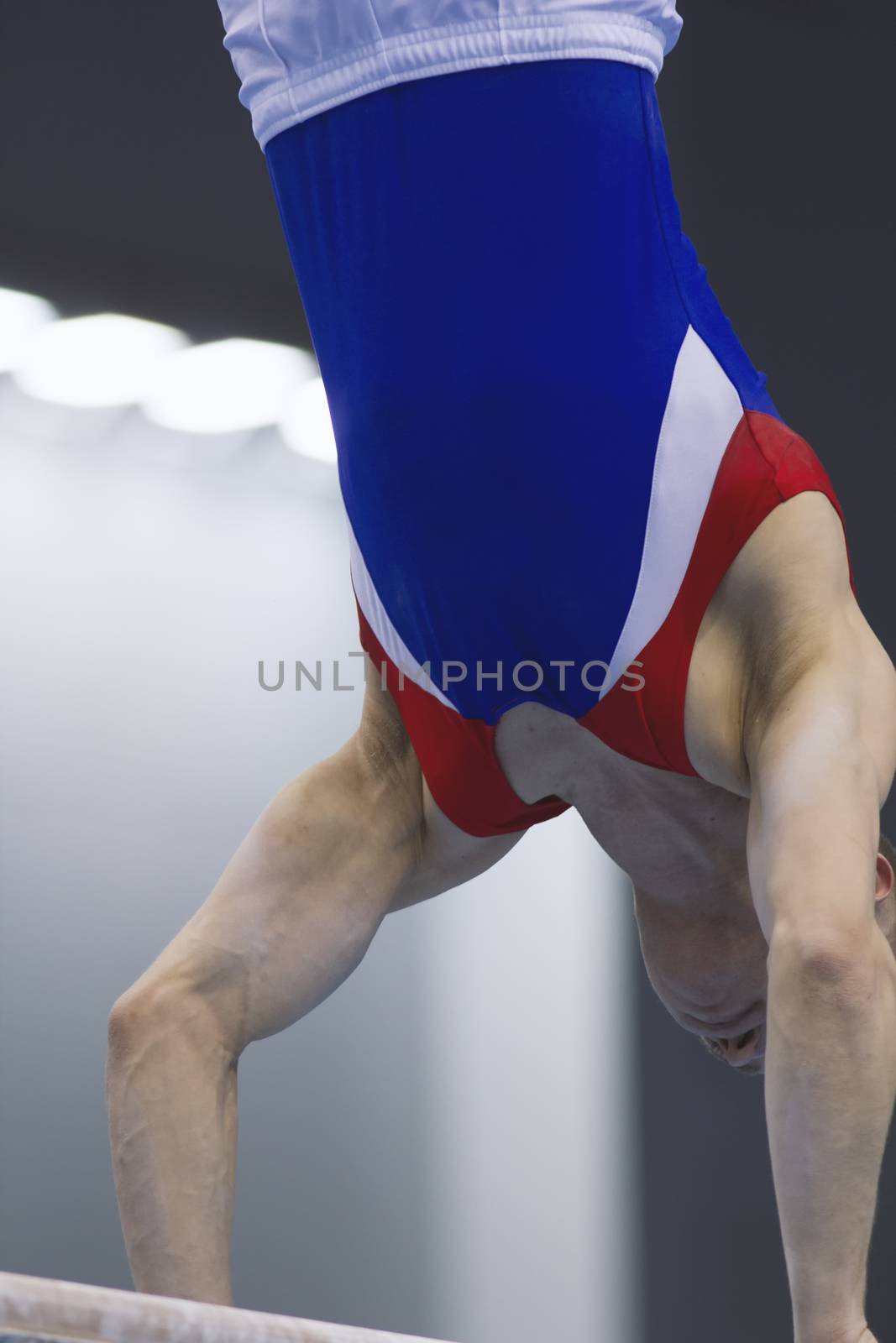 Muscular man gymnasts competing on the bar, close up