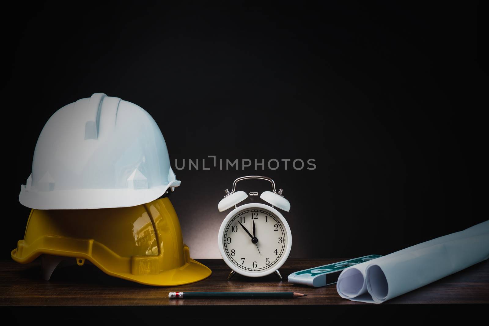 real estate, property and construction project concept, engineer's tools  with helmet on table in dark background 