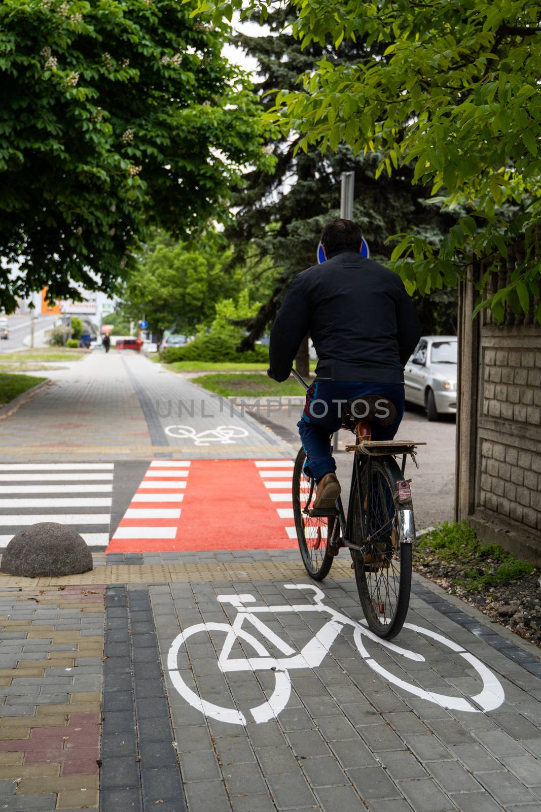 UKRAINE, LUTSK - May 10, 2020: Man riding on bike at the city street on a bike path