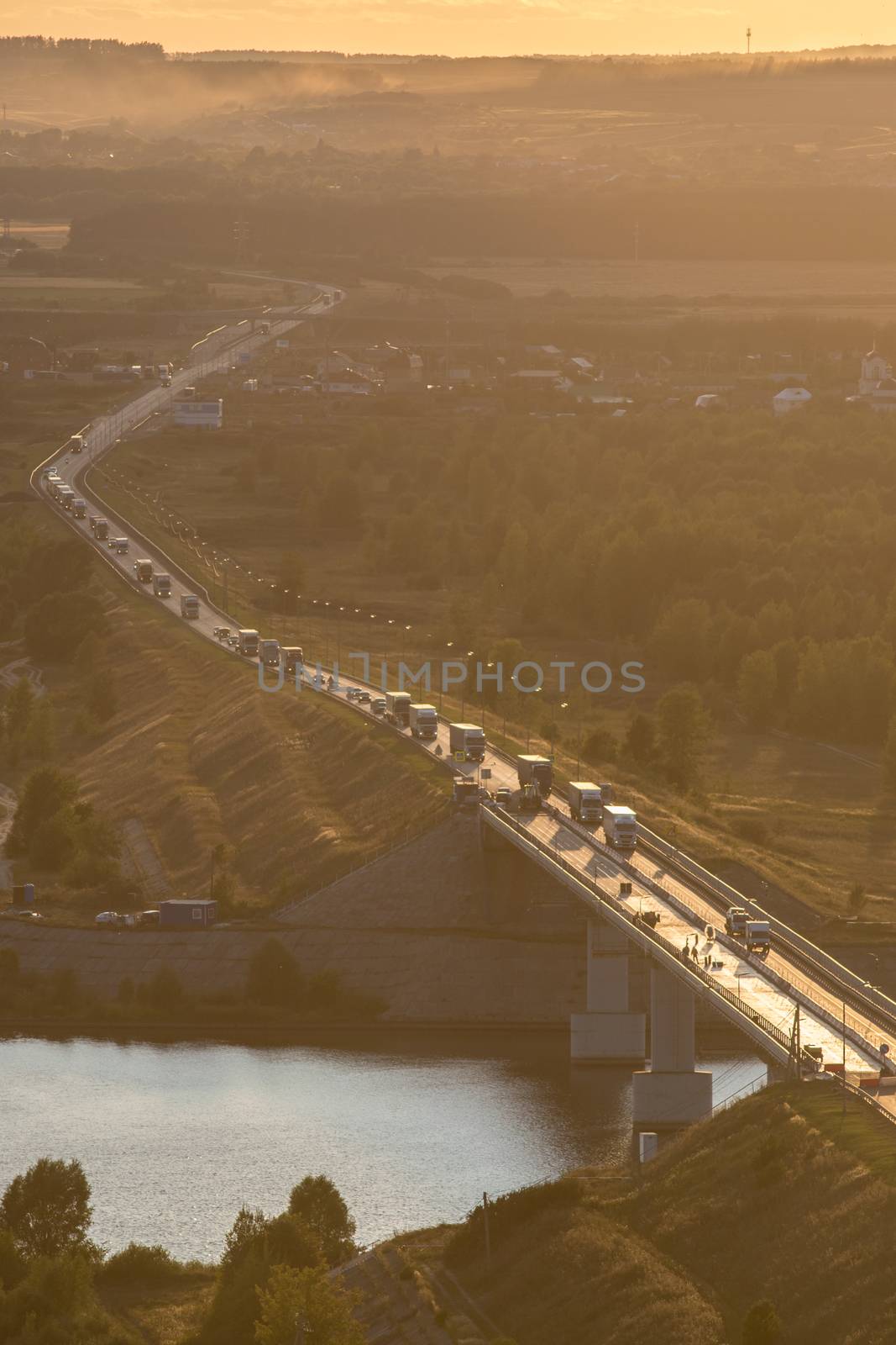 Stream of cars on sunset , car traffic on bridge, vertical shot