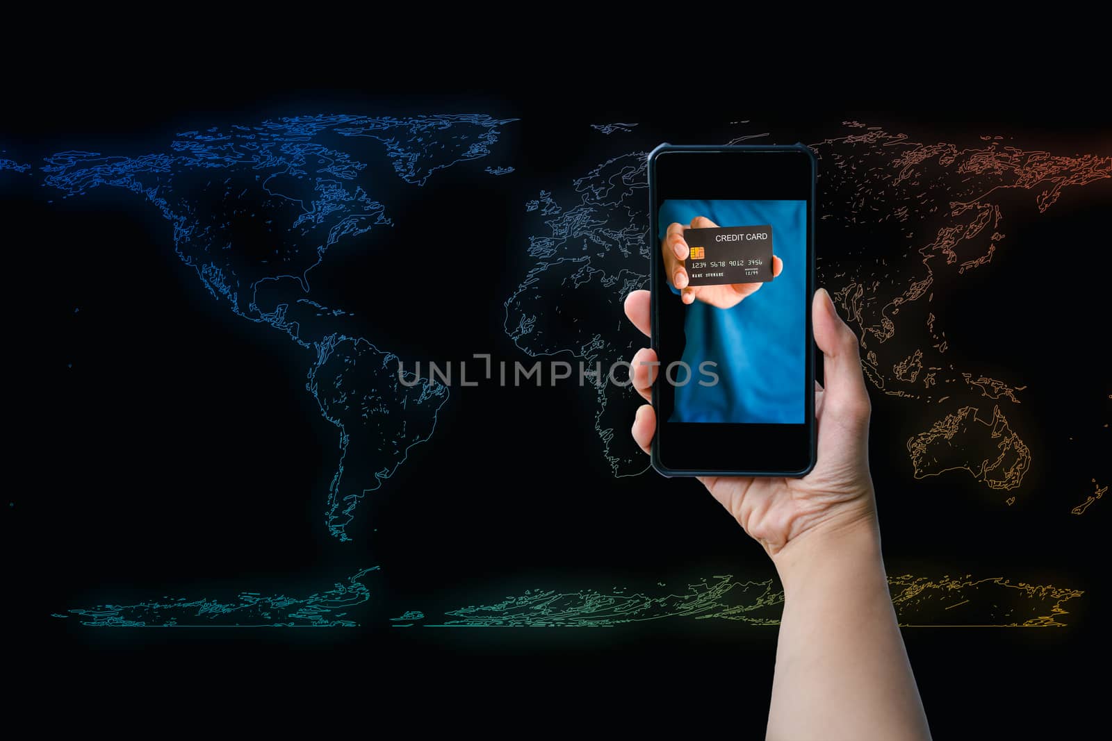 Shopping online concept. Hand holding credit card on the screen of a smartphone or mobile on the colorful world map with a black background.