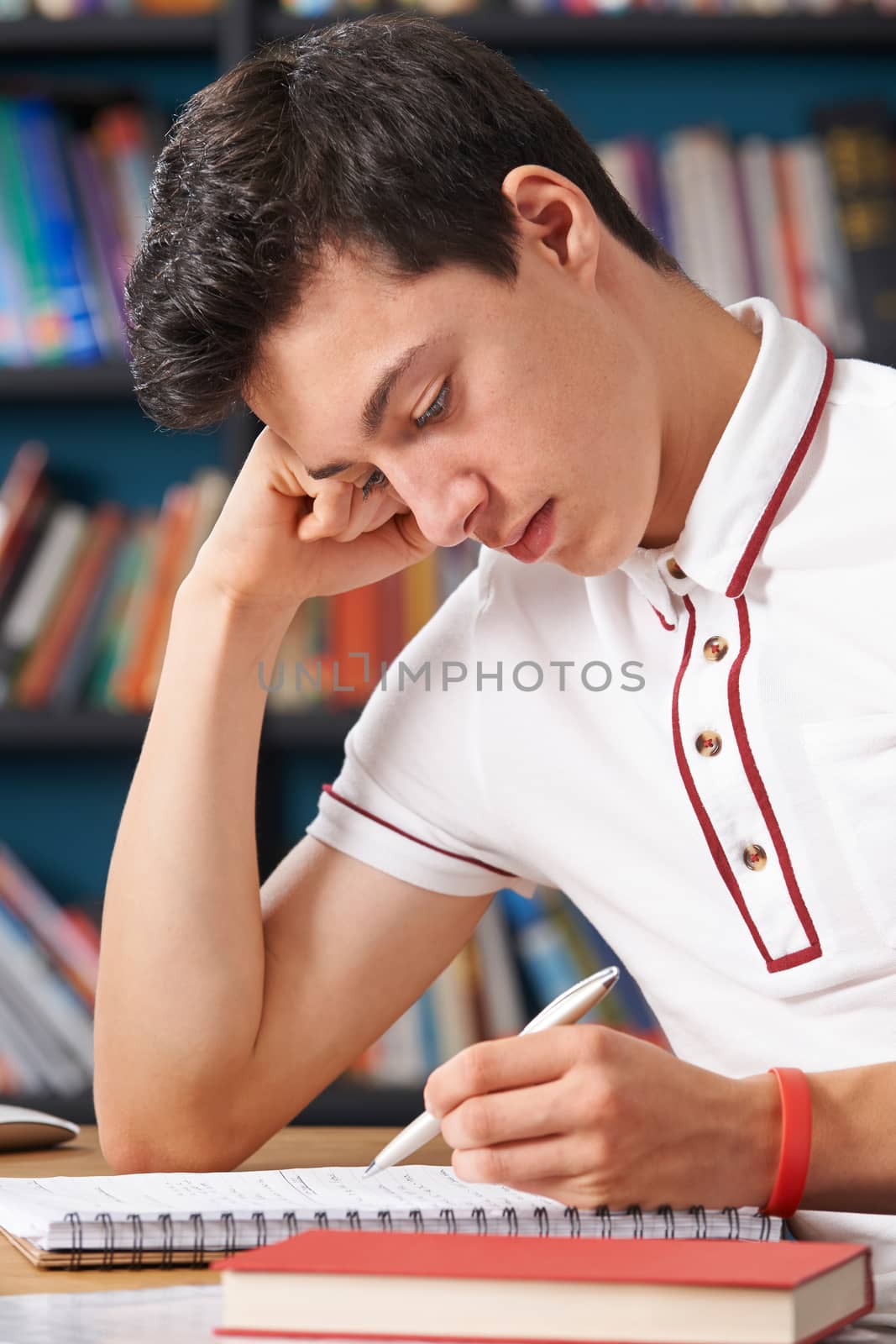 Fed Up Male Student Working In Library