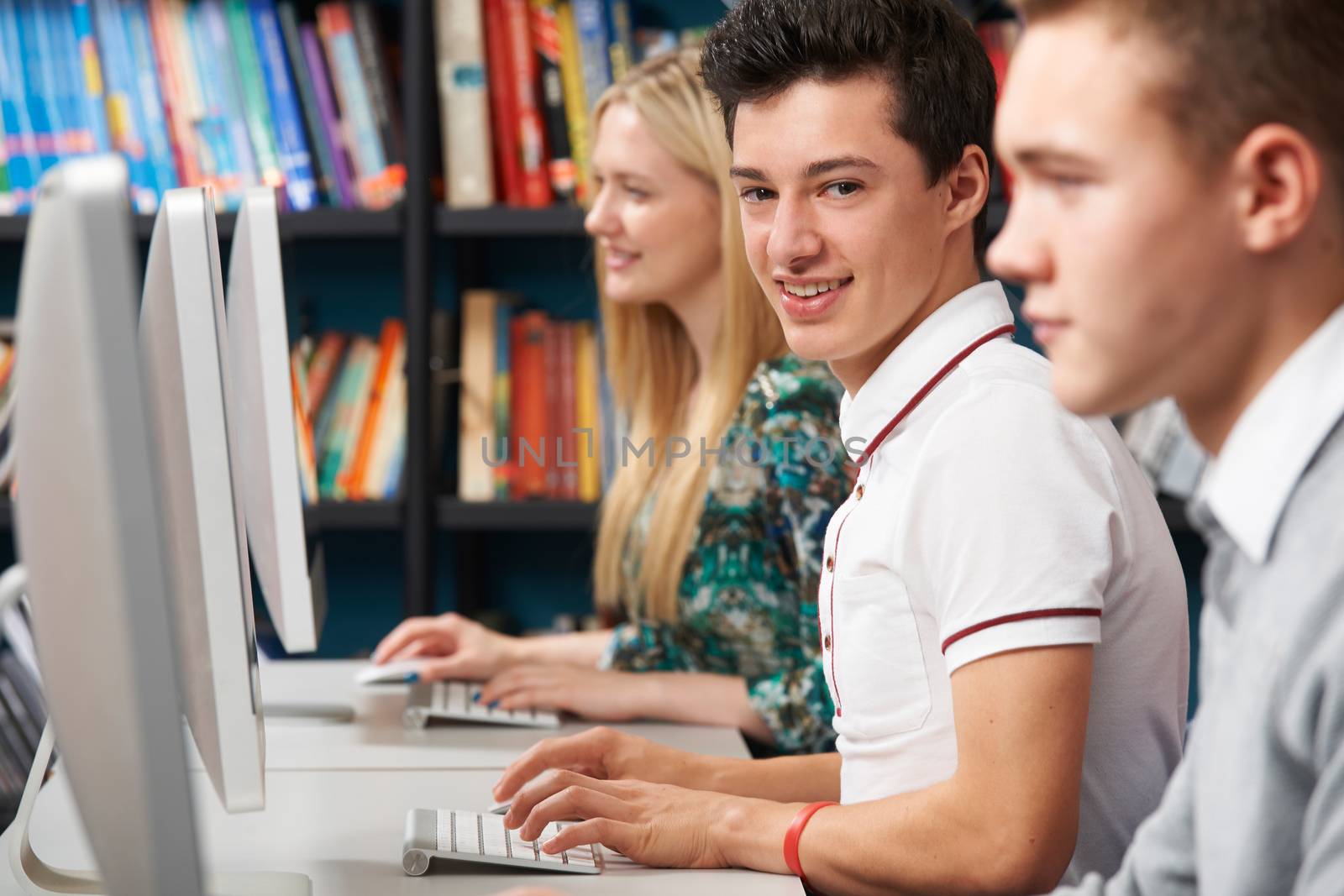 Group Of Teenage Students Working At Computers In Classroom by HWS