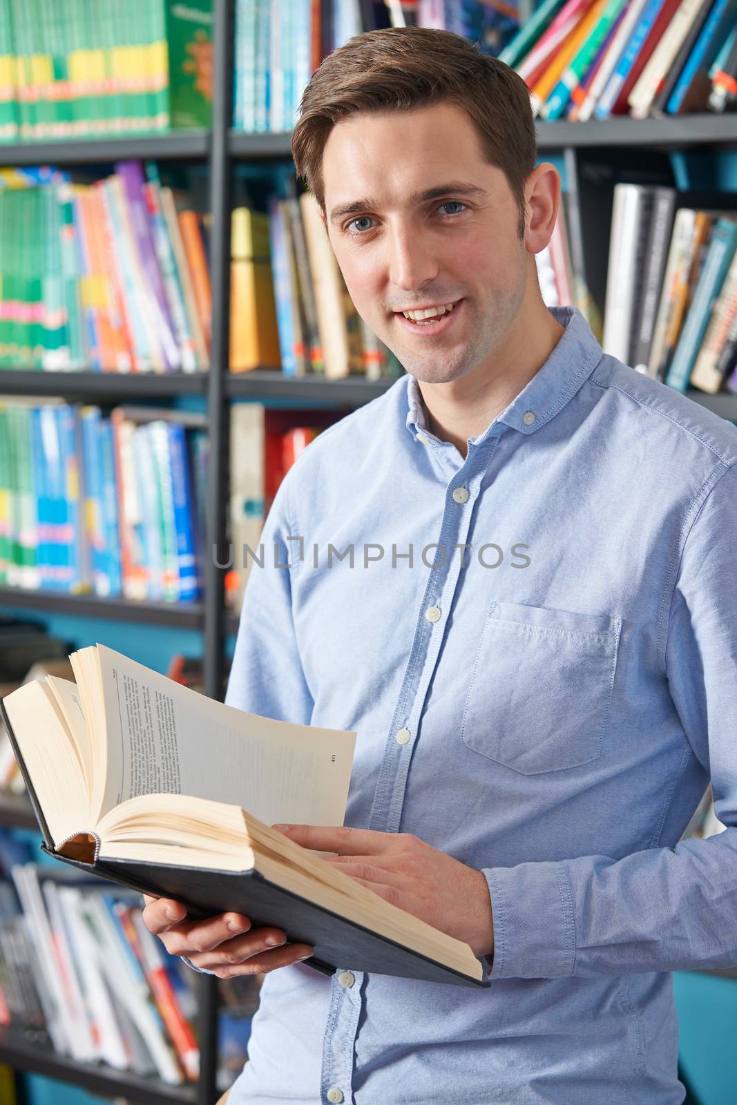 University Student Reading Textbook In Library