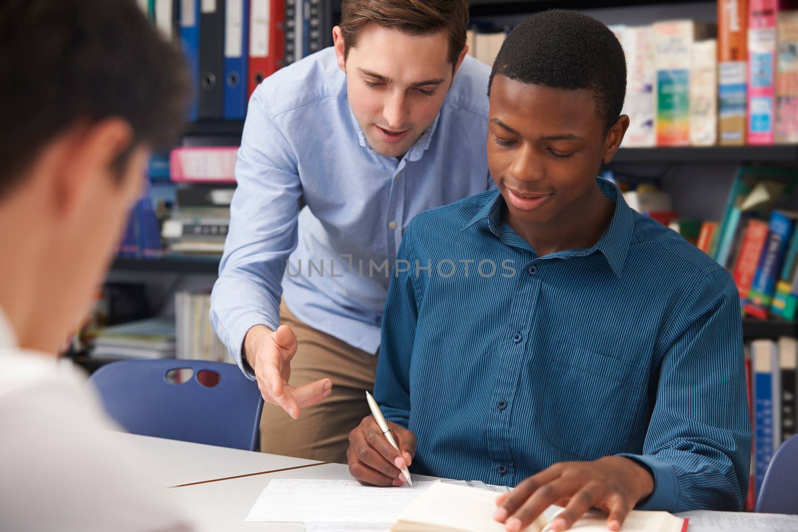 Teacher Helping Male Pupil In Class by HWS