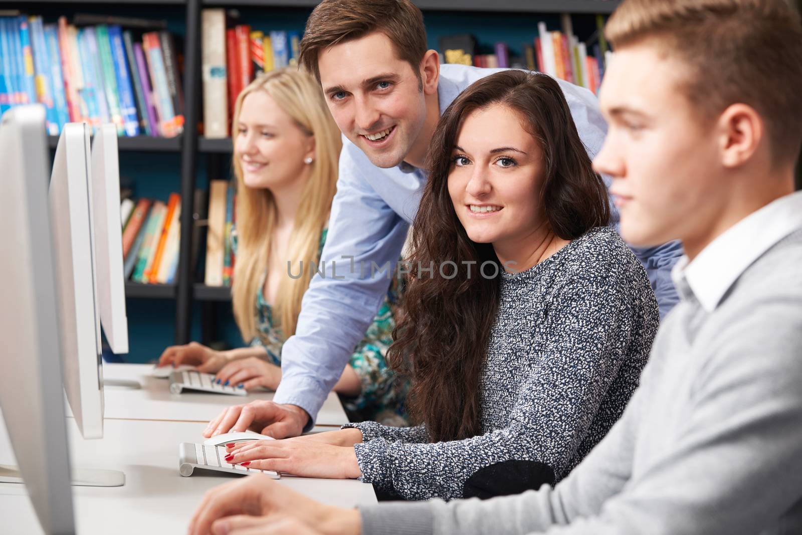 Tutor Helping Students Working At Computer