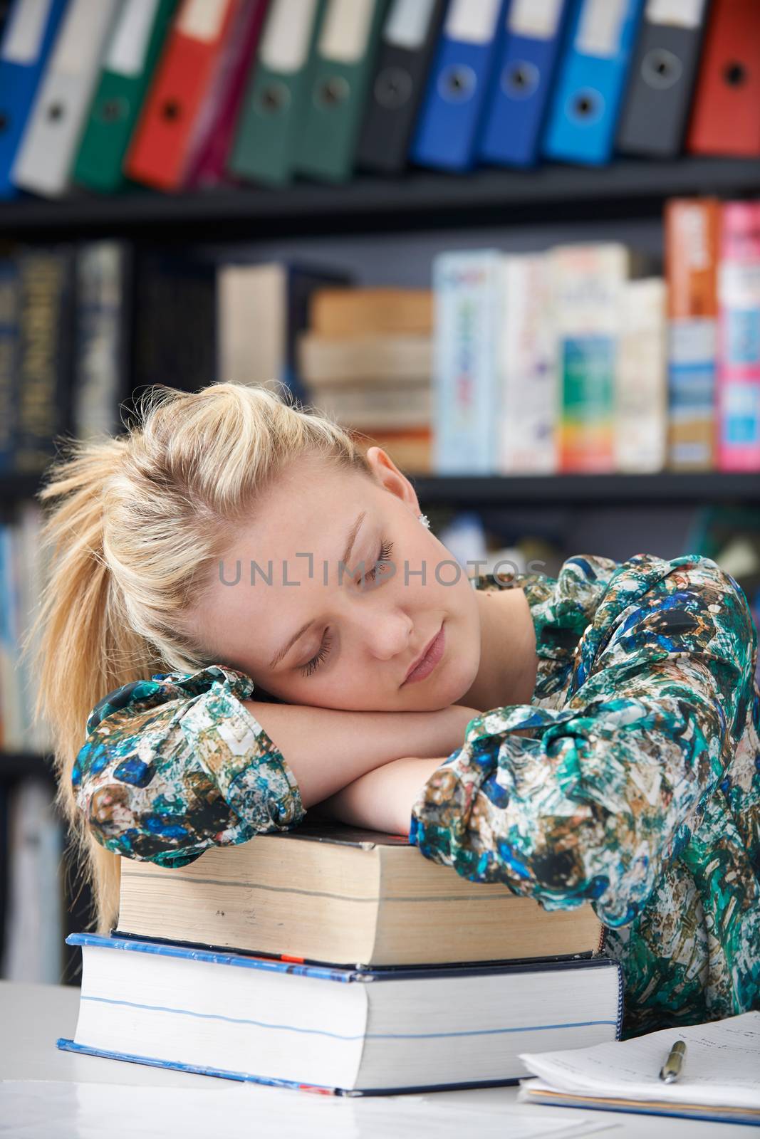 Tired Female Teenage Student Sleeping In Library by HWS