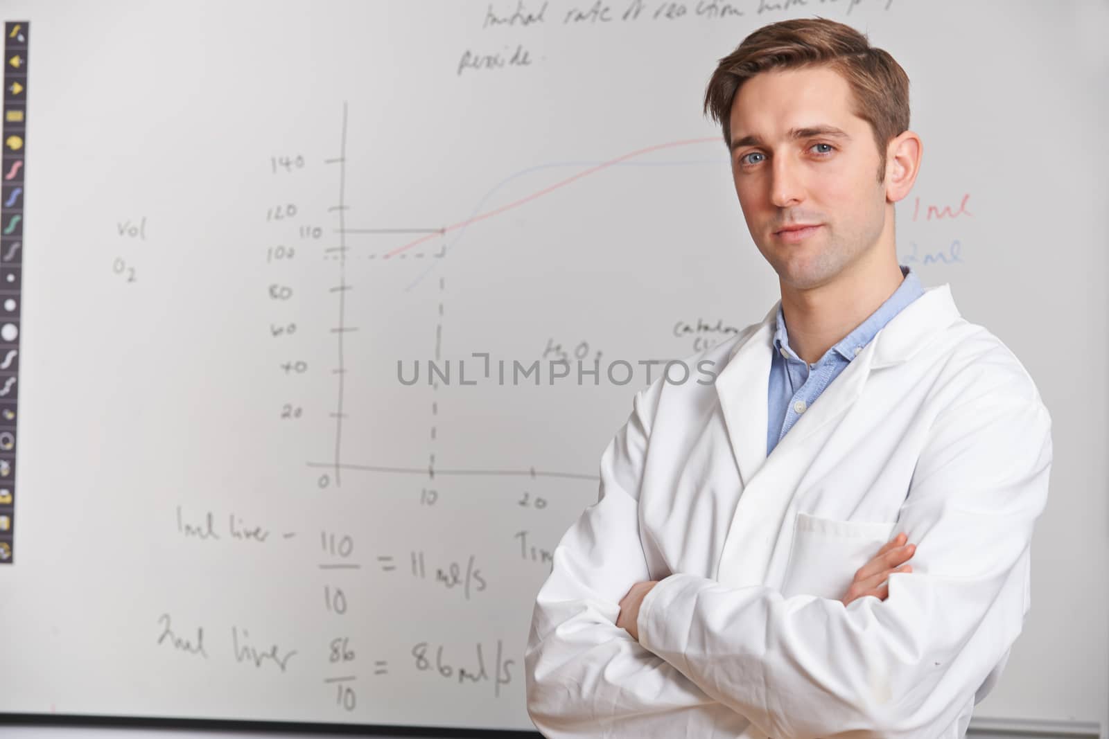 Portrait Of Science Teacher Standing In Front Of Whitebaord by HWS