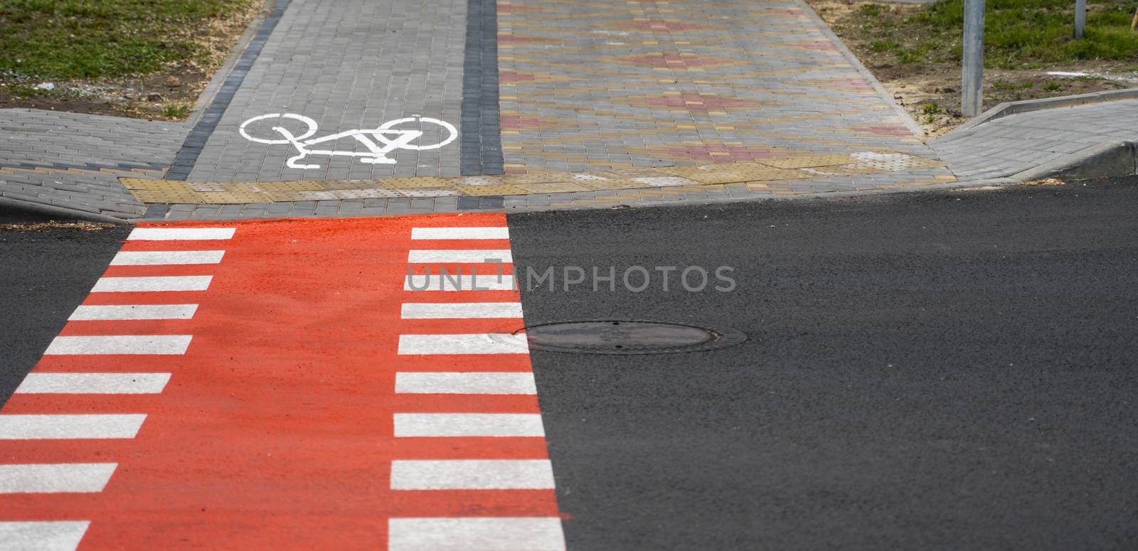 Cycling path with a symbol of bike on a ground through avtomobile road. Bike path in a modern city. by vovsht