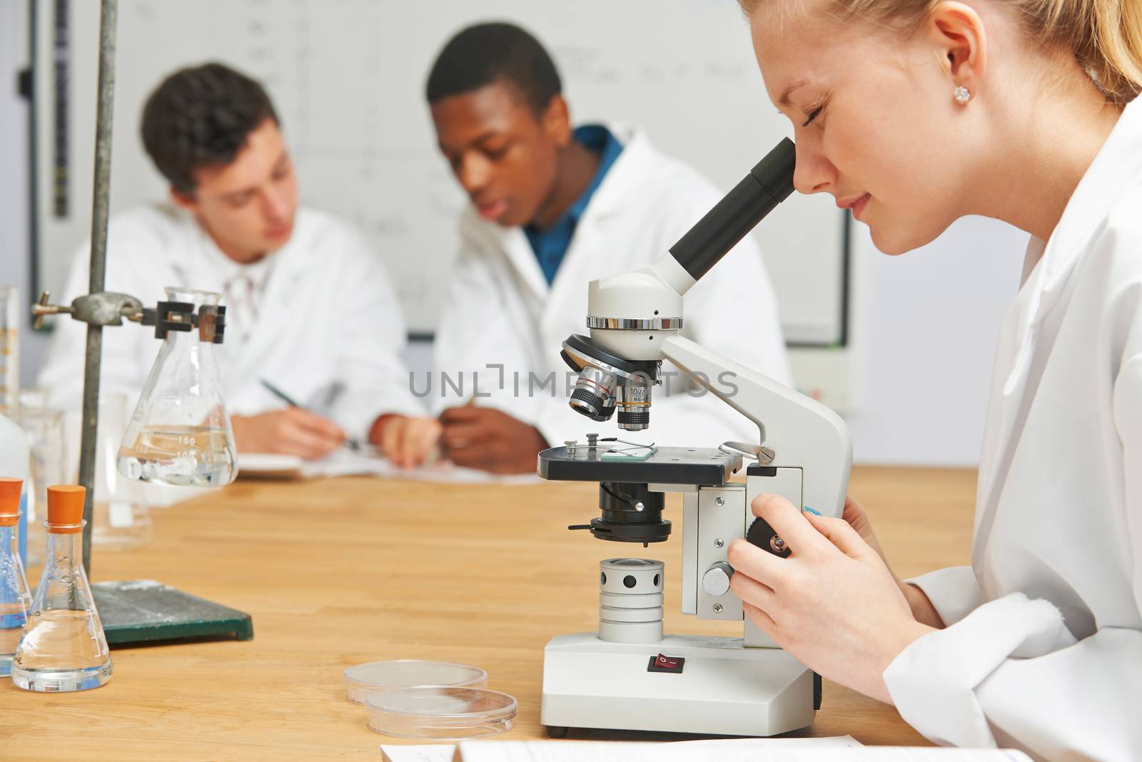 Teenage Students In Science Class Using Microscope by HWS