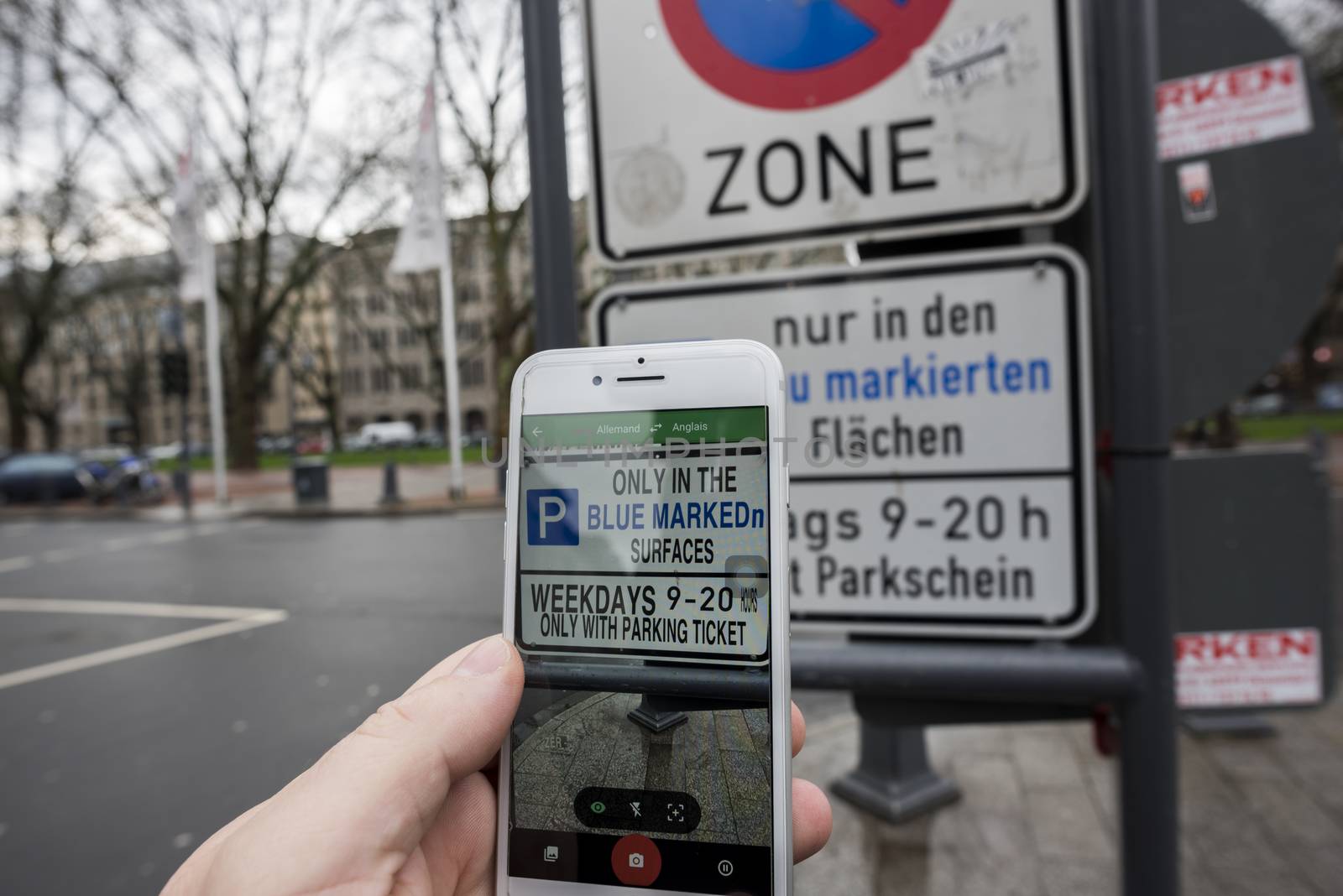 Man using augmented reality apps (here Google Translate) to translate text from german to english instantly with his iPhone
