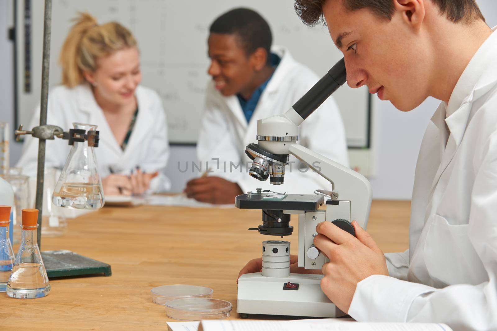 Teenage Students In Science Class Using Microscope by HWS
