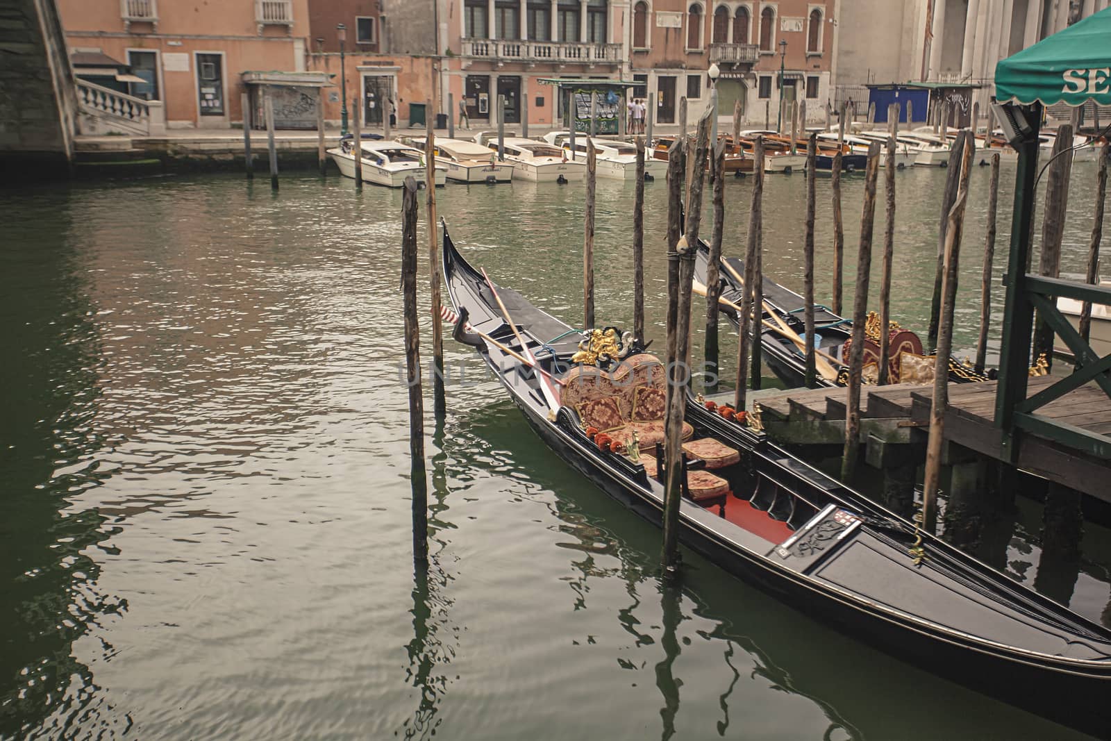 Two Gondolas moored in Venice in Canal Grande during a cloudy day