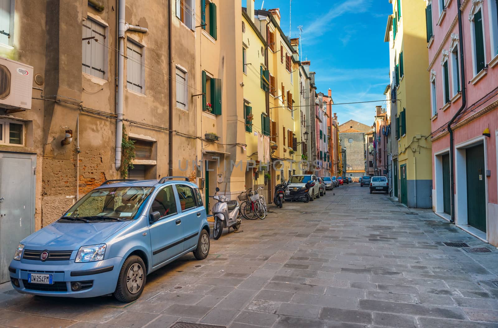 Chioggia - January 2015, Italy: Cars parked near traditional colored houses in Venetian style on one of the streets in historic part of the old Italian city