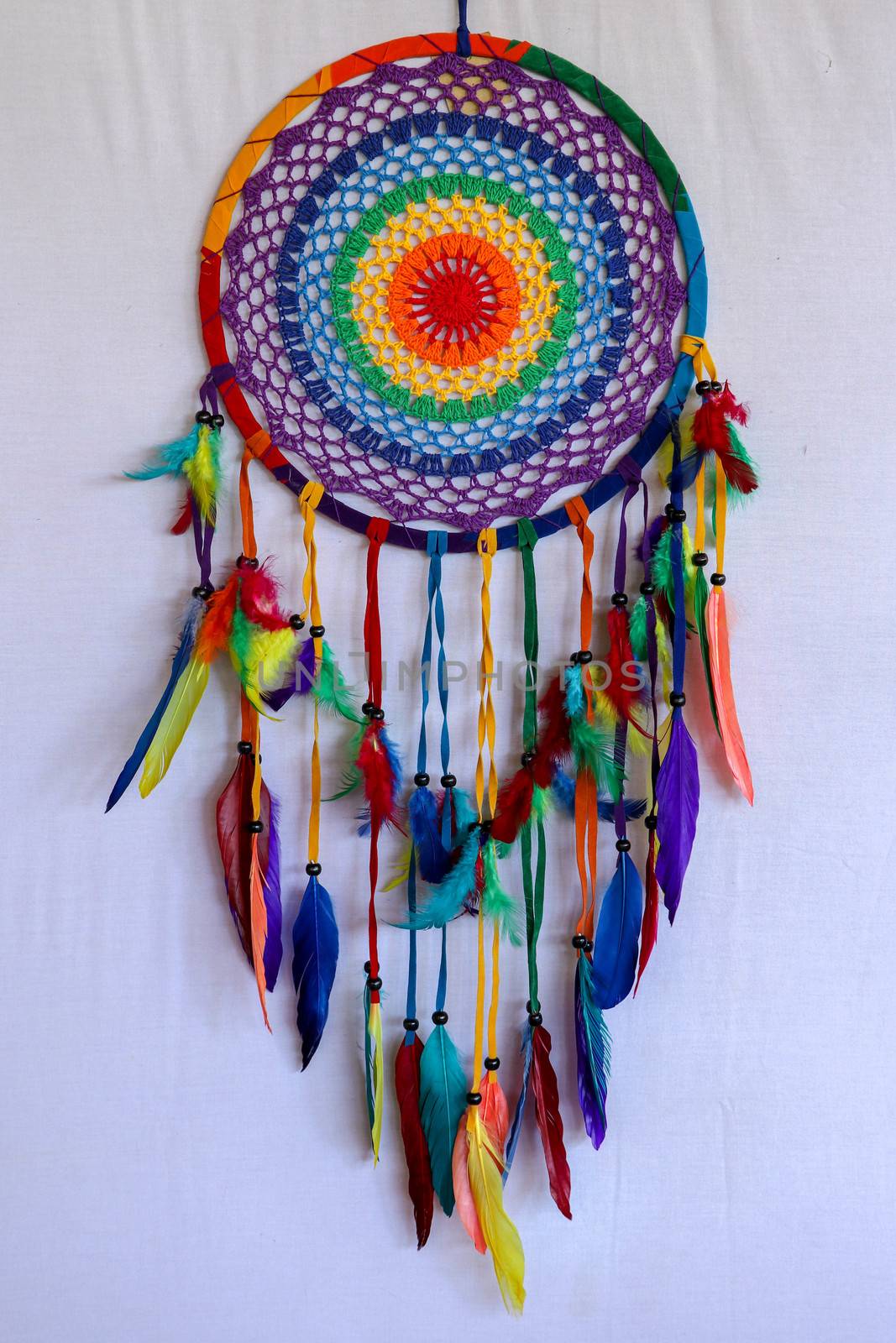 Beautiful multicolored handmade dreamcatcher on white background.