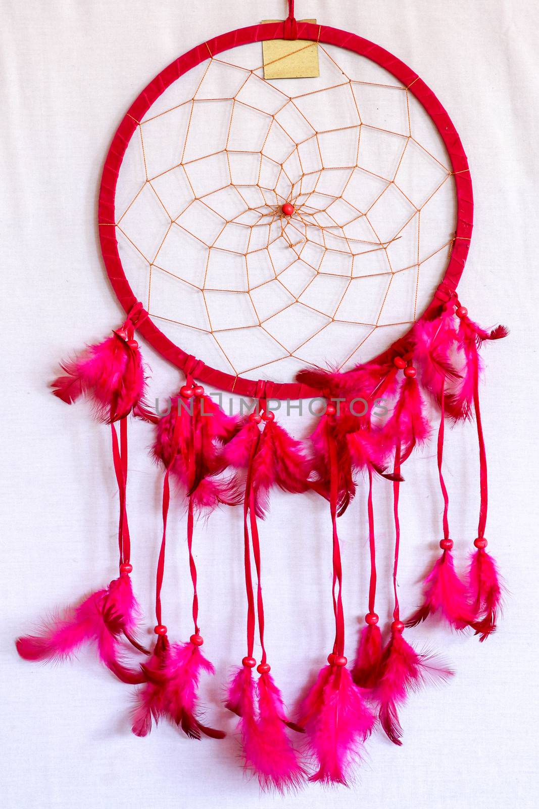 Pink ash crochet doily dream catcher close up on dark gray textured background. Texture of concrete, copy space for text. White background.