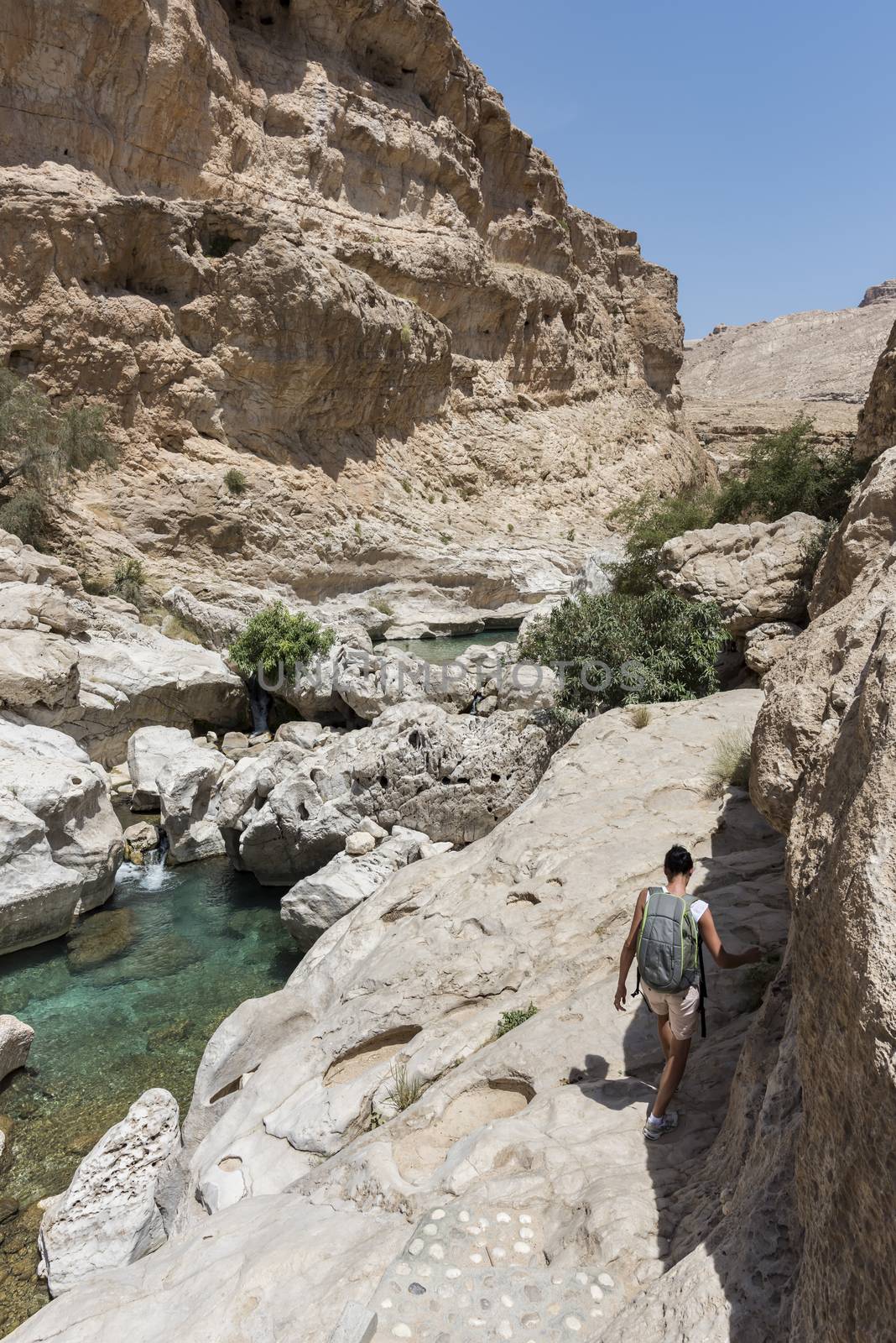 Woman in the 40s trekking near the river and pool in the canyon of Wadi Bani Khalid, in Oman, Middle East