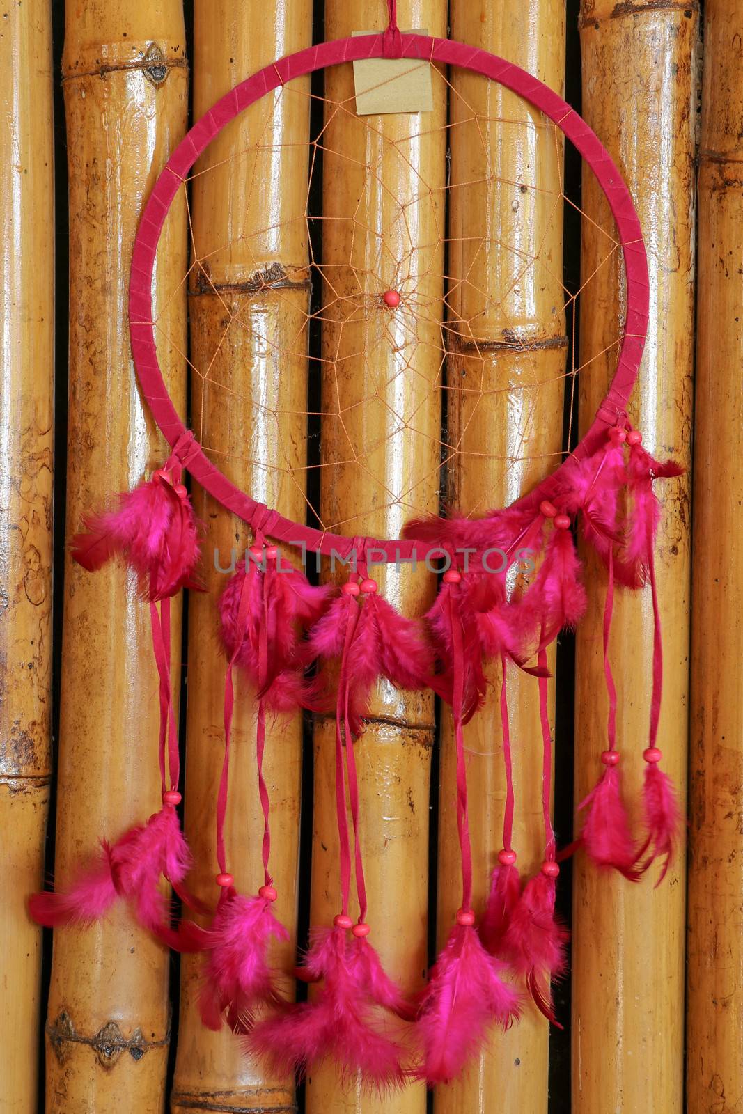 Pink ash crochet doily dream catcher close up on dark gray textured background. Texture of concrete, copy space for text. Wodden background.