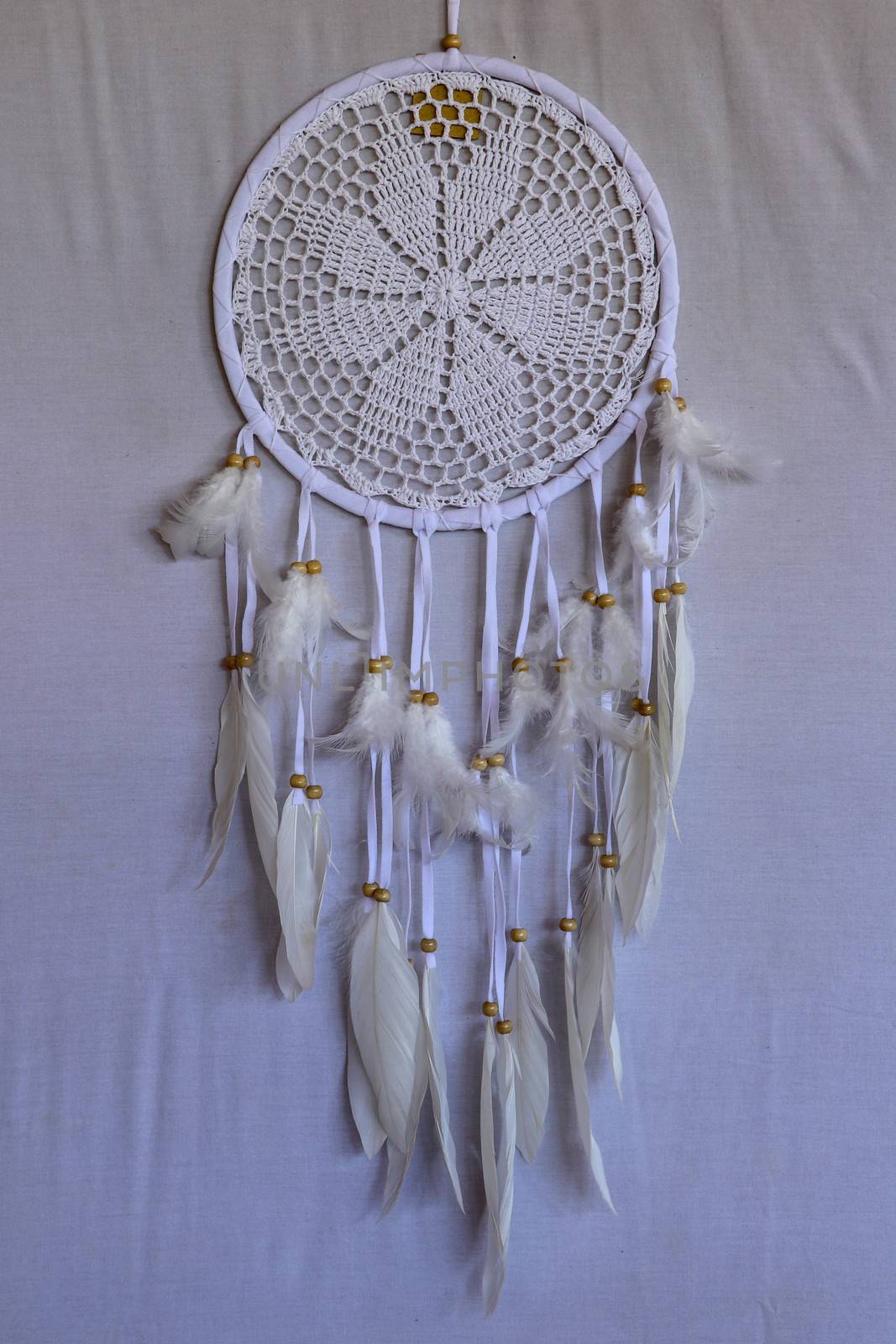 White crocheted dreamcatcher, an Indian amulet that protects the sleeper from evil spirits and diseases. Soft focus. Closeup.