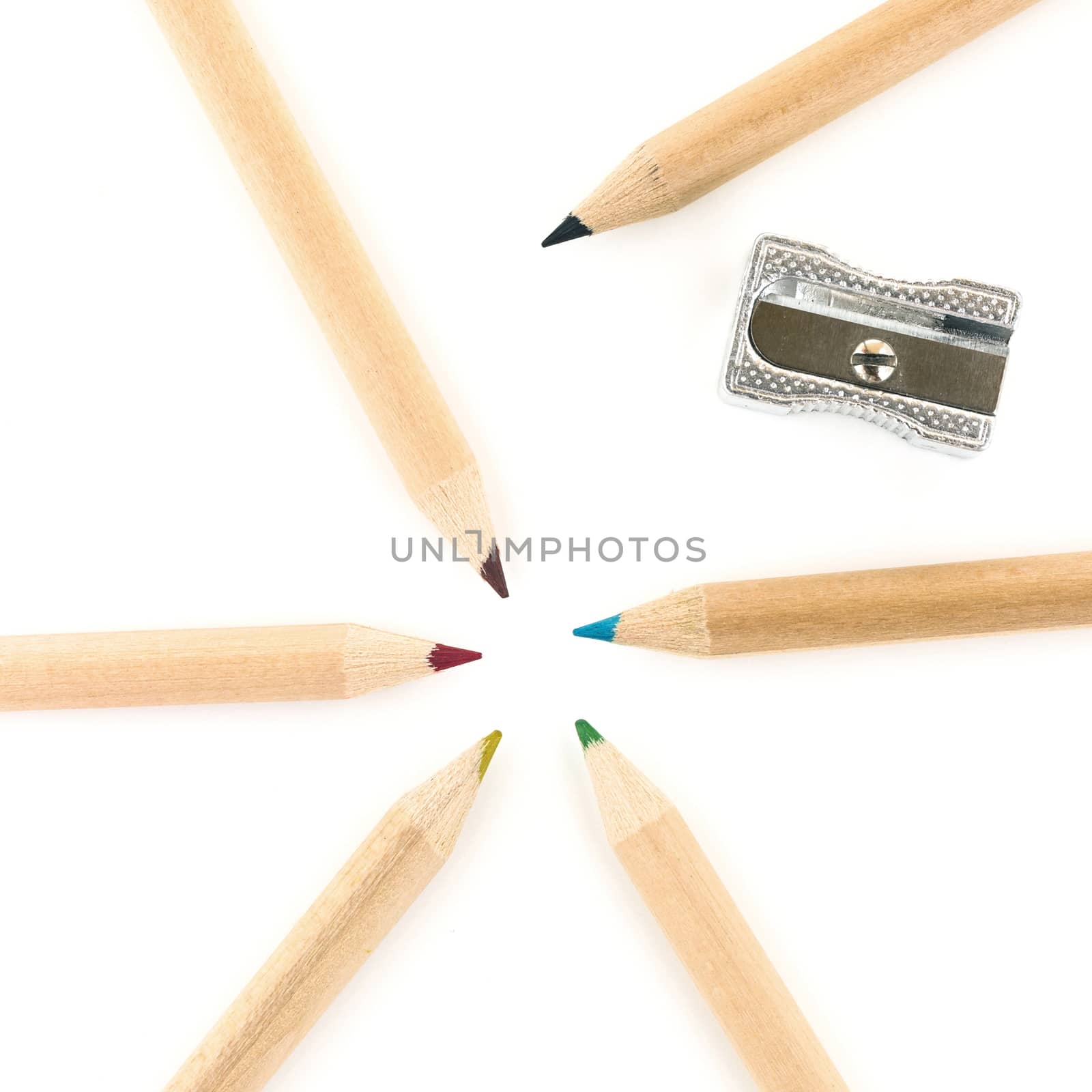 Colorful pencils and sharpener over white background