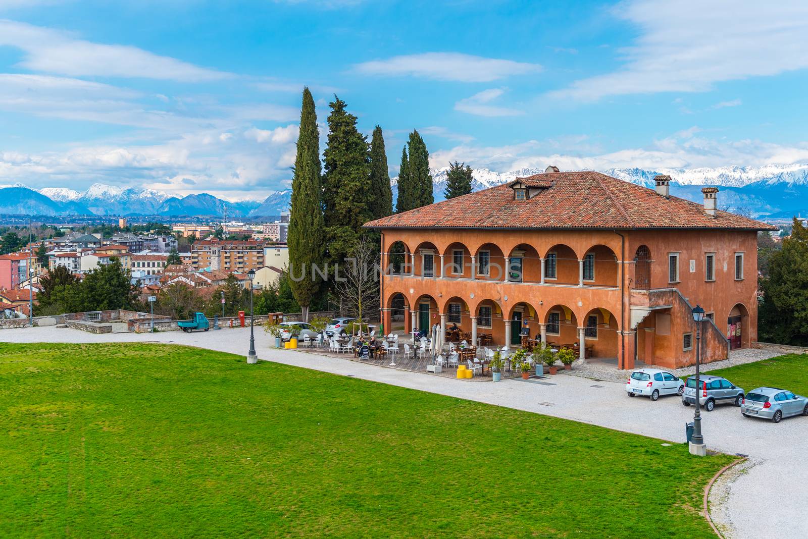 Udine - March 2016, Italy:  Panoramic view of the city, old historical restaurant building and the mountains to the north from Udine Castle