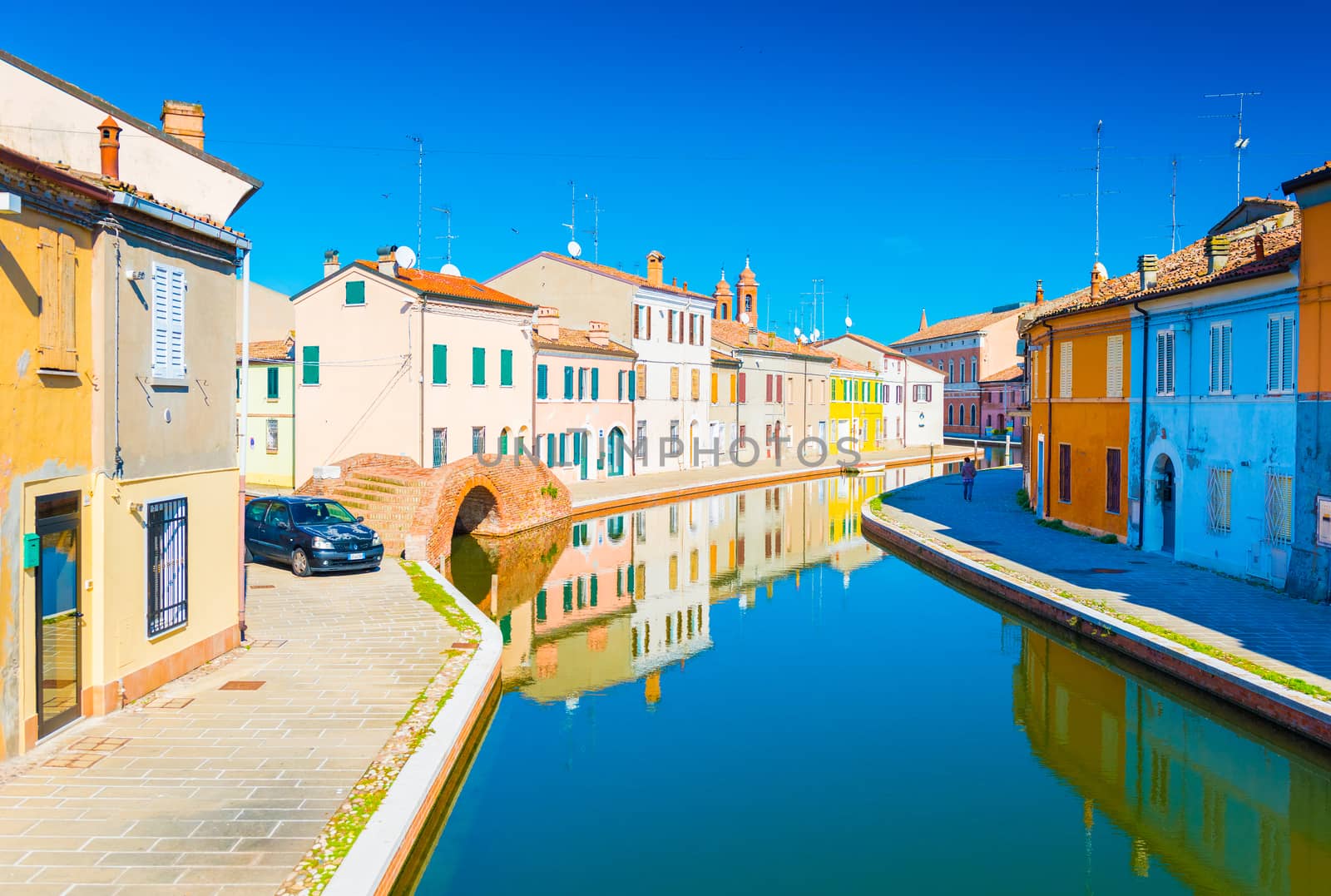 Comacchio - October 2016, Emilia Romagna, Italy: View of the canal with bridge and  colored houses reflected in the water. Italian town of Comacchio also known as the "Little Venice"