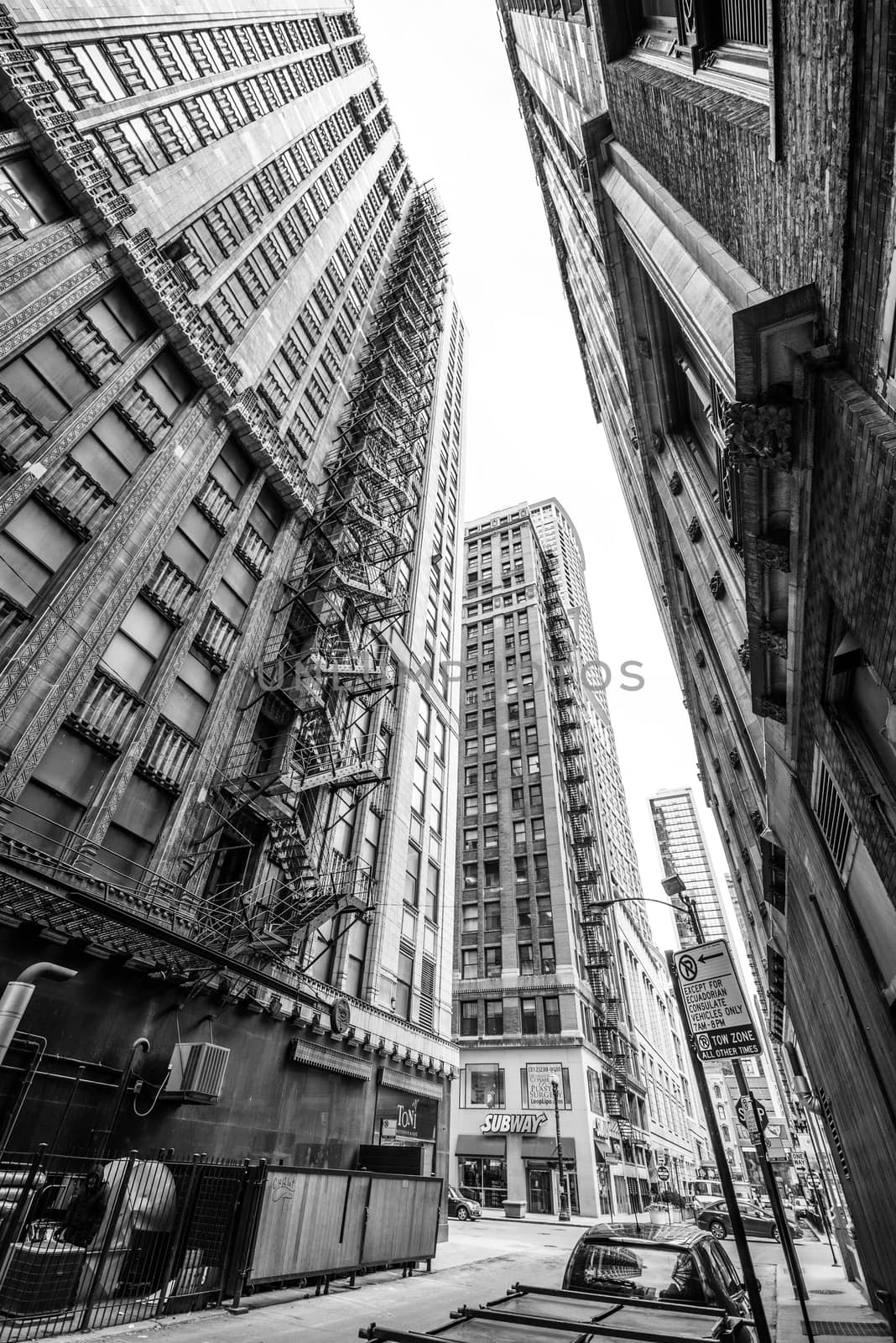 Chicago - March 2017, USA: View through narrow street between skyscrapers in downtown Chicago. Black and white photography