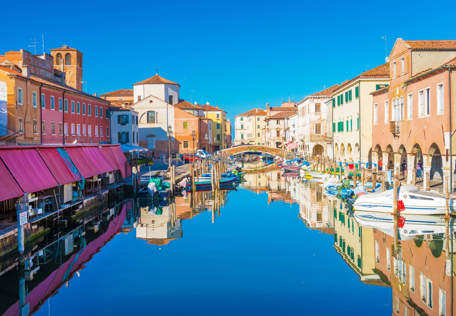 Chioggia - September 2016, Veneto, Italy: Cityscape of Chioggia historic city center. Canal Vena with boats lying on water and colored houses in traditional architectural style