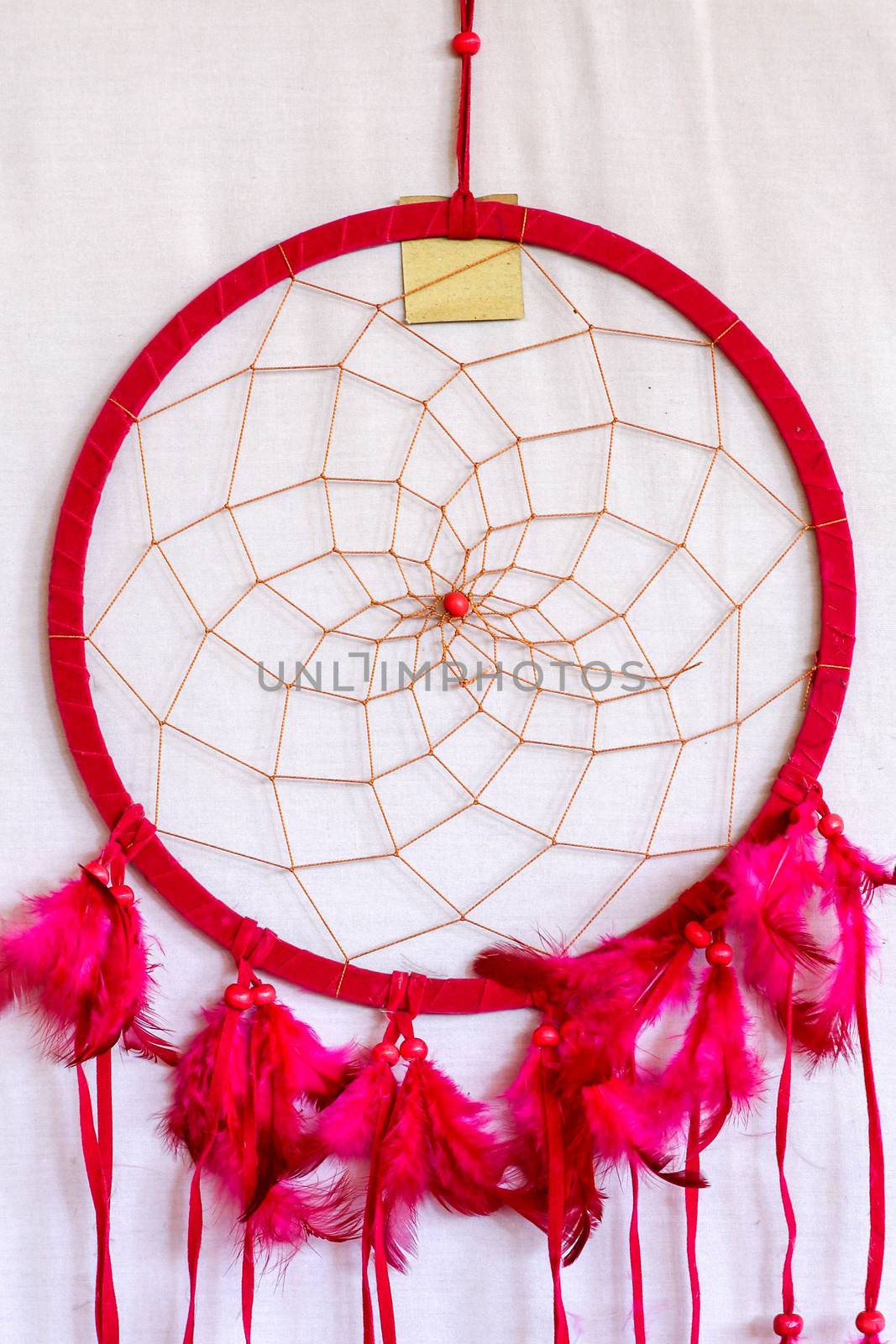 Pink ash crochet doily dream catcher close up on dark gray textured background. Texture of concrete, copy space for text. White background.