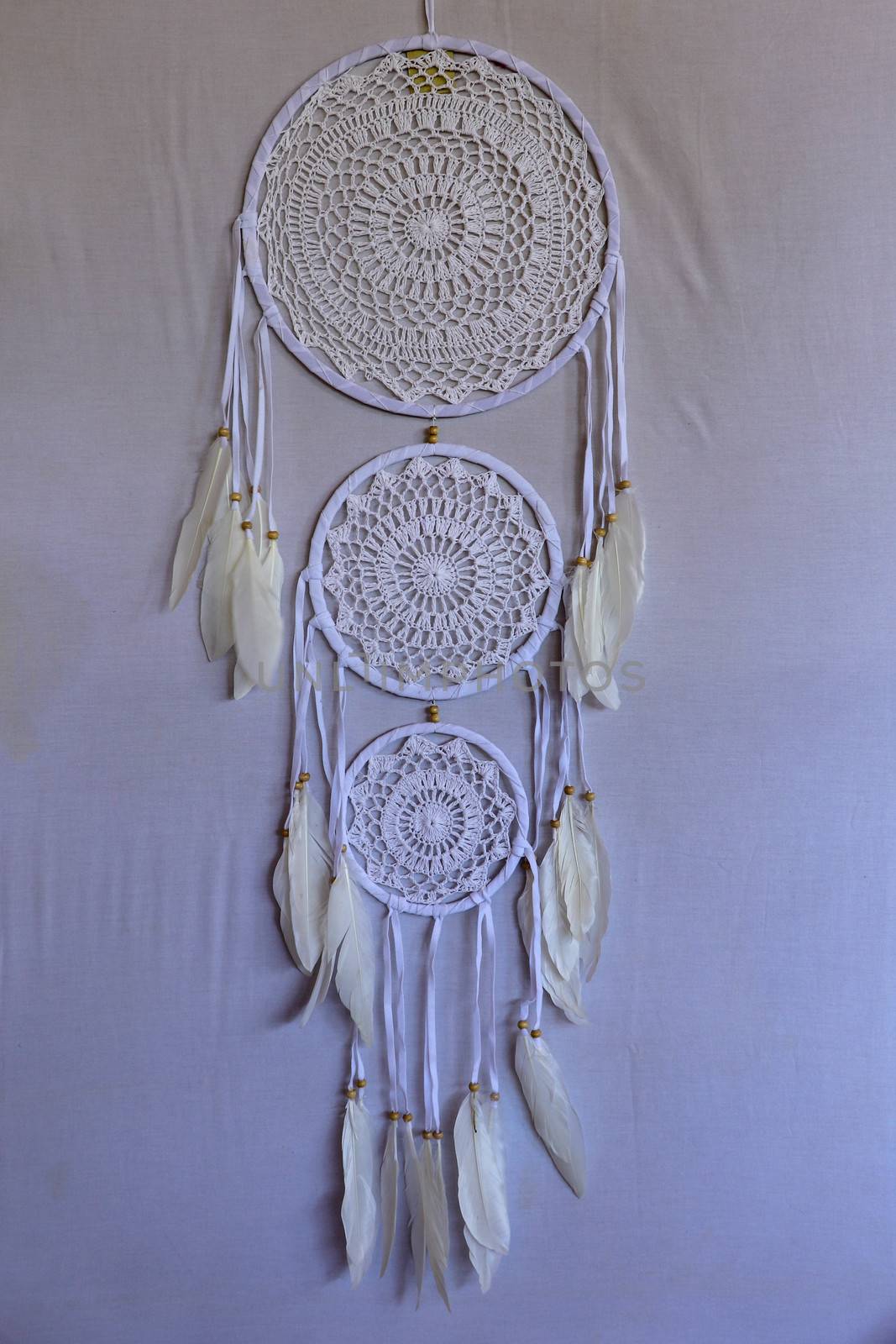 White crocheted dreamcatcher, an Indian amulet that protects the sleeper from evil spirits and diseases. Soft focus. Closeup.