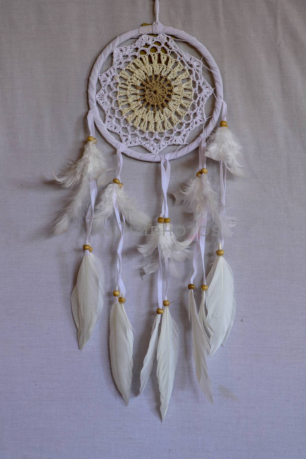 White crocheted dreamcatcher, an Indian amulet that protects the sleeper from evil spirits and diseases. Soft focus. Closeup.