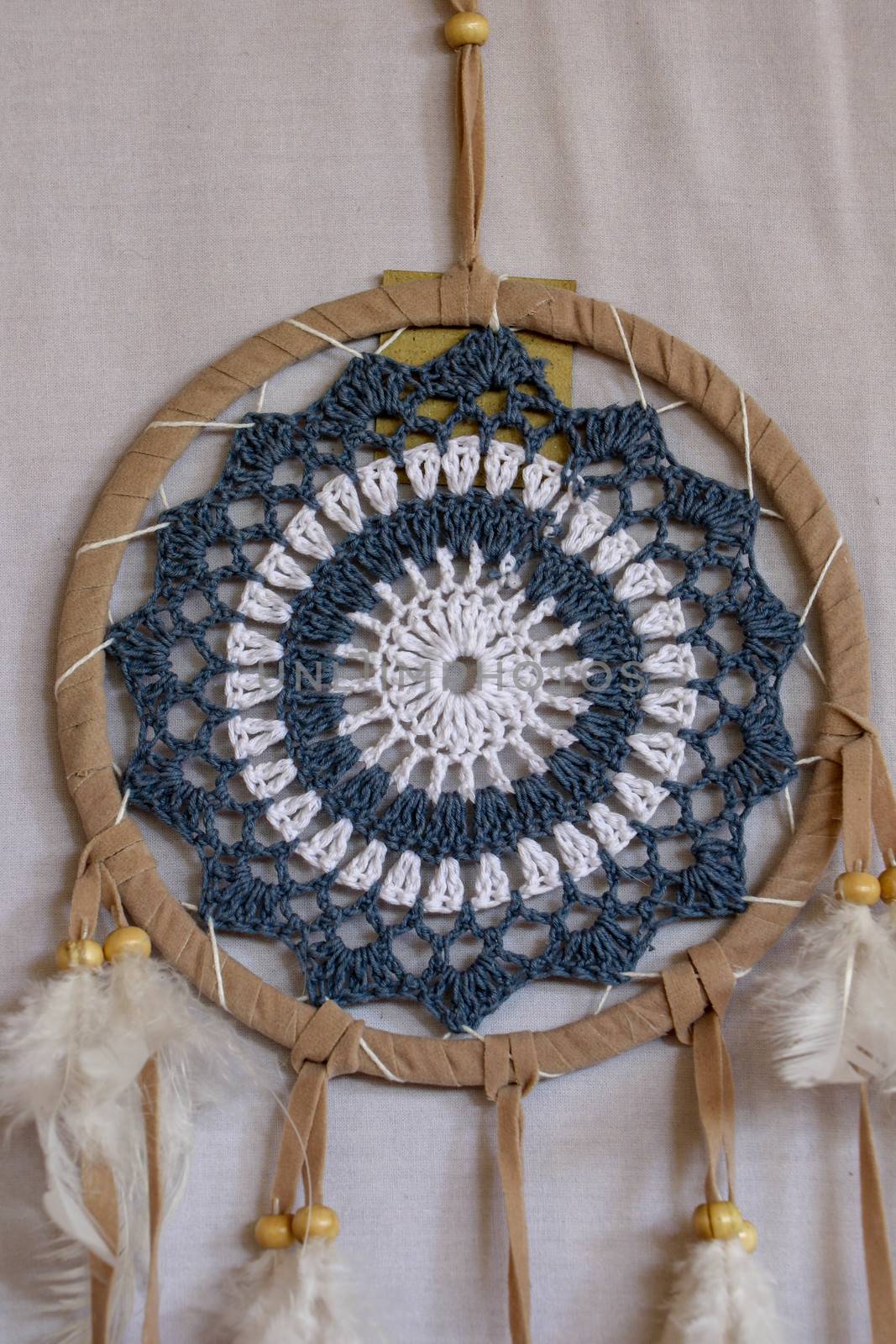 Blue Dreamcatcher with feathers and beads isolated on a white background.