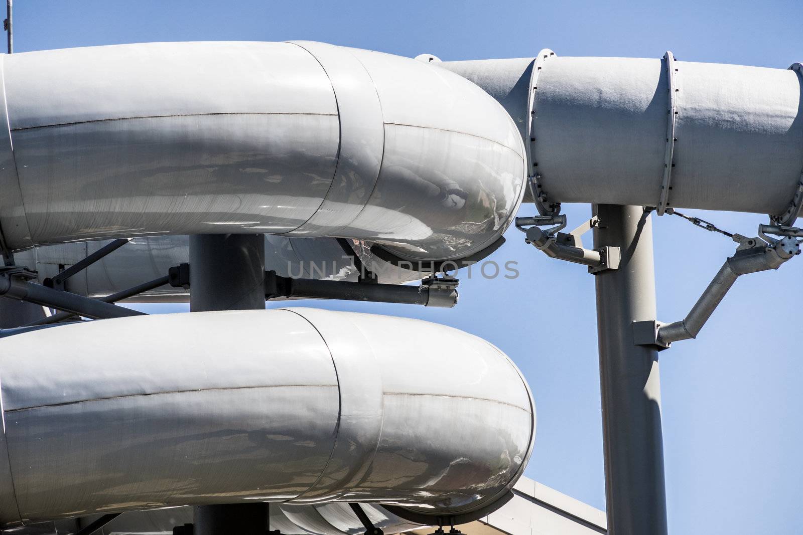 Detailed view of the serpentines of the tubes of a water slide of an indoor swimming pool by geogif