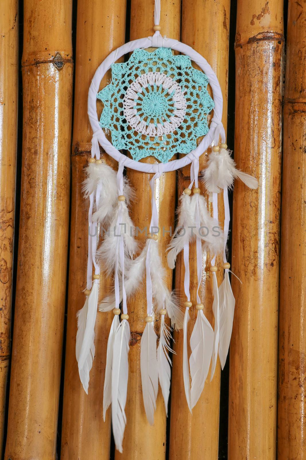 Dream catcher with blue turquoise threads closeup in the interior.