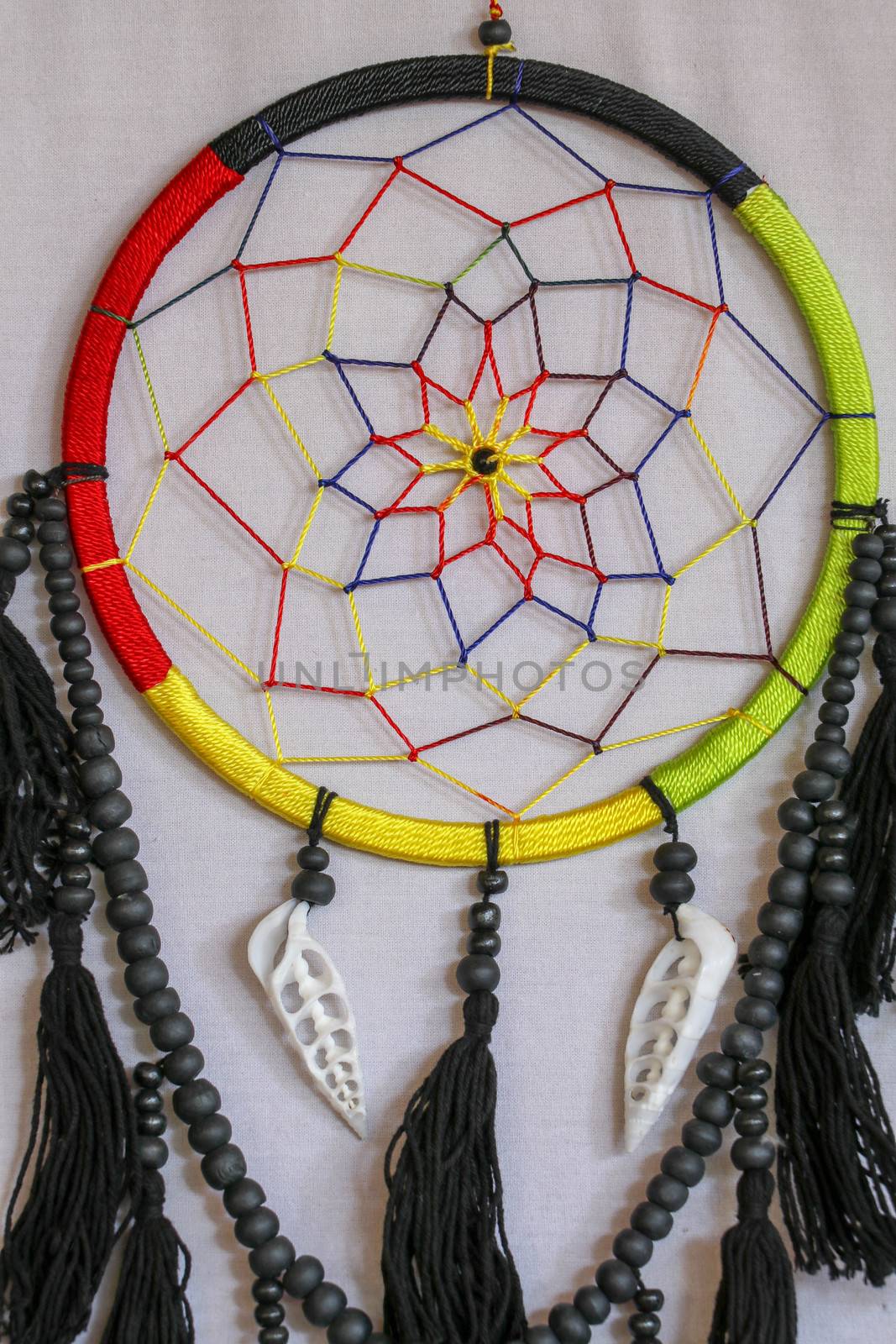 Beautiful multicolored handmade dreamcatcher with sea shells on white background.