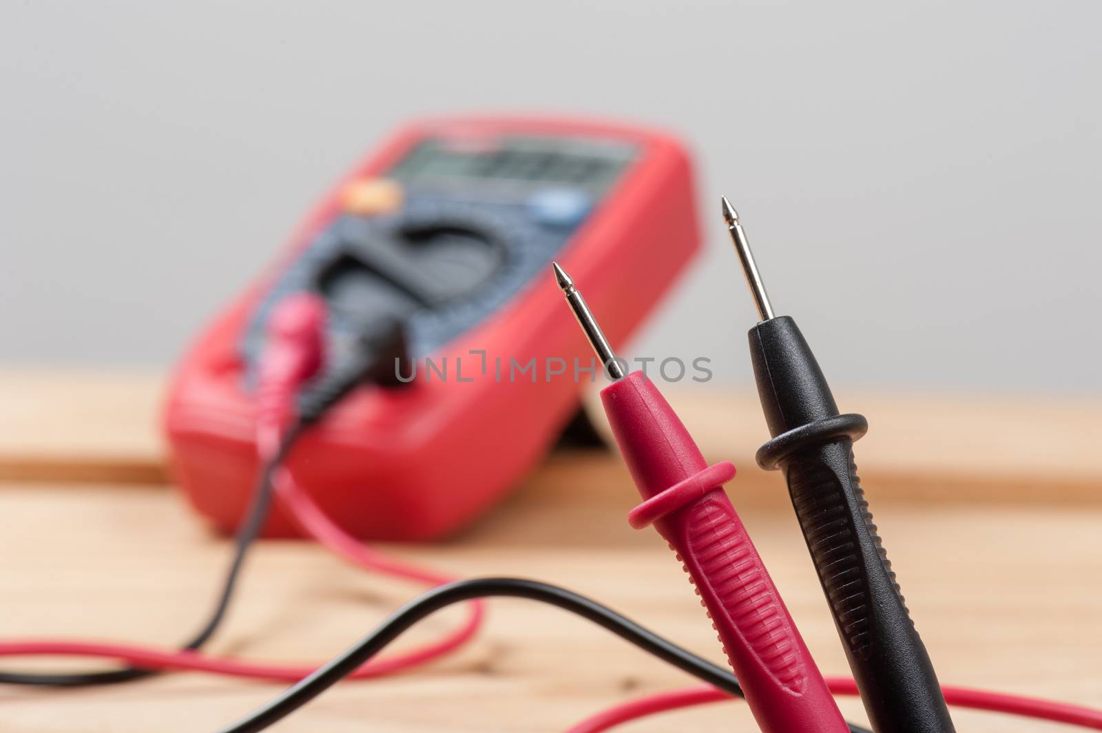 digital multimeter or multitester or Volt-Ohm meter (closeup at test leads), an electronic measuring instrument that combines several measurement functions in one unit.