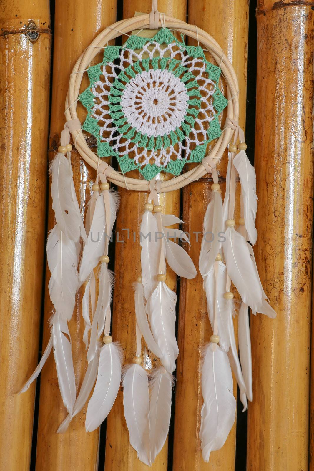 Beautiful green dream catcher on wodden background.