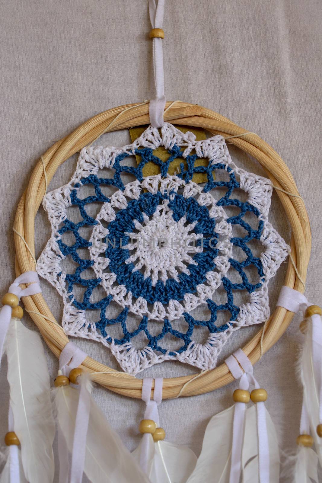 Blue Dreamcatcher with feathers and beads isolated on a white background.