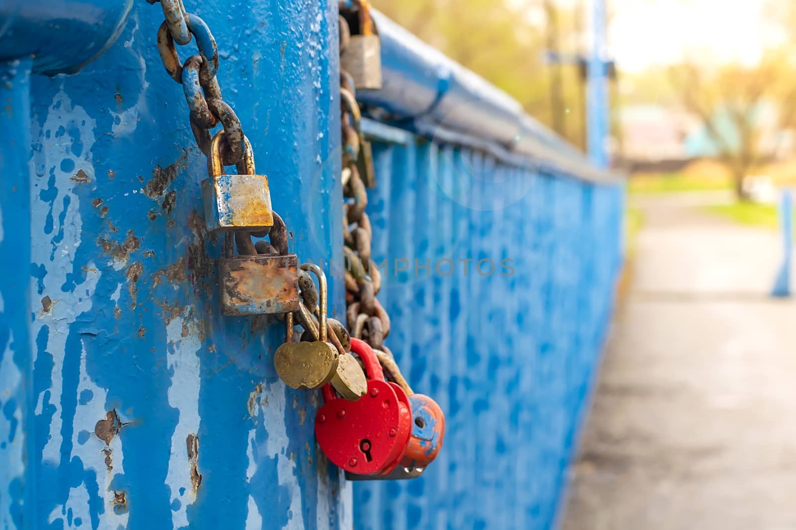 memorable wedding locks in the form of hearts, symbols of love, hang chained to the handrails of the pedestrian bridge